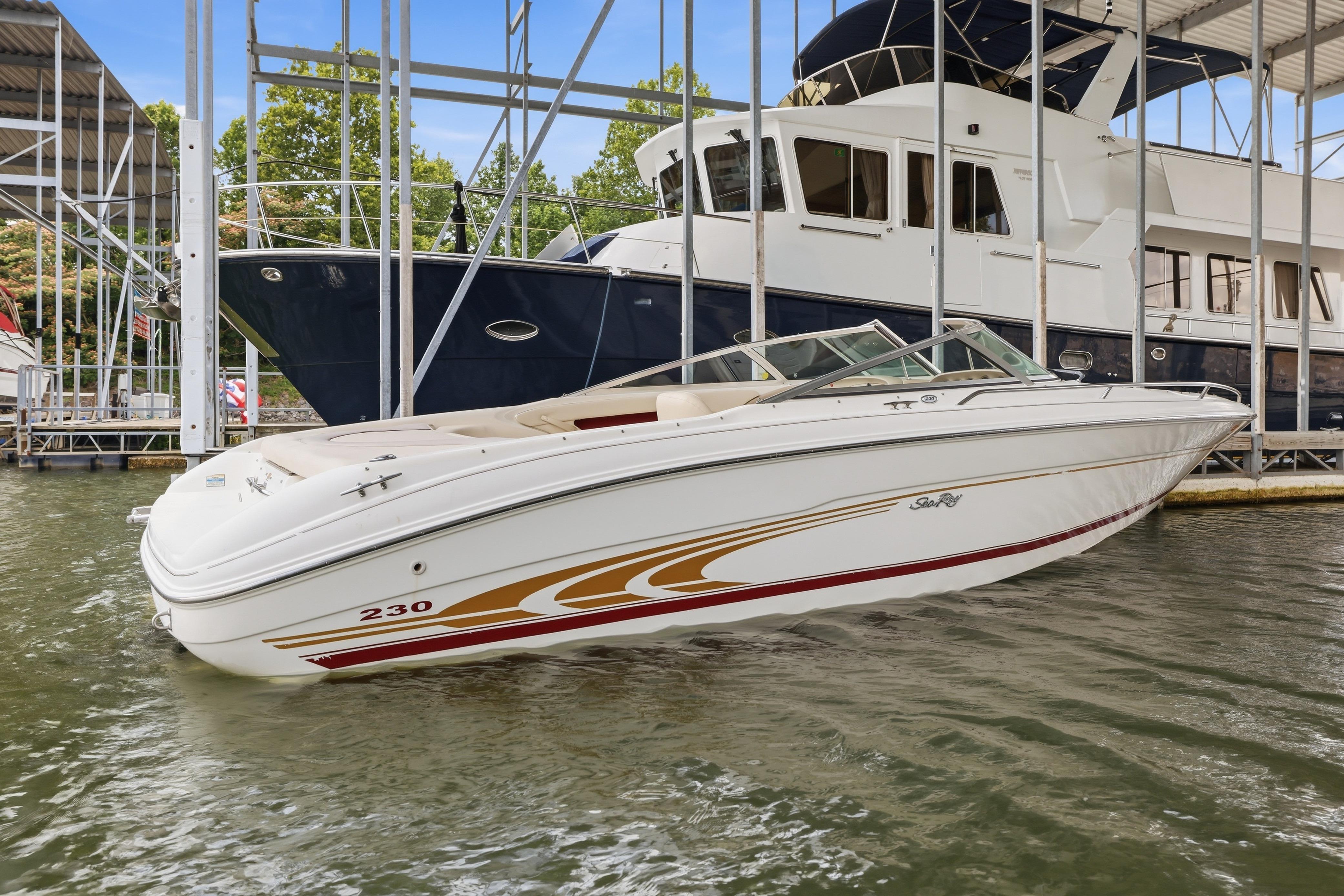 1997 Sea Ray 230 Signature boat docked in marina, featuring sleek white design.