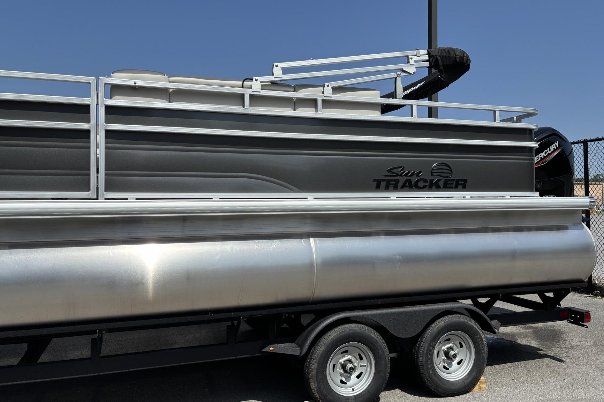2026 Sun Tracker Fishin' Barge 20 DLX pontoon boat on trailer, side view.