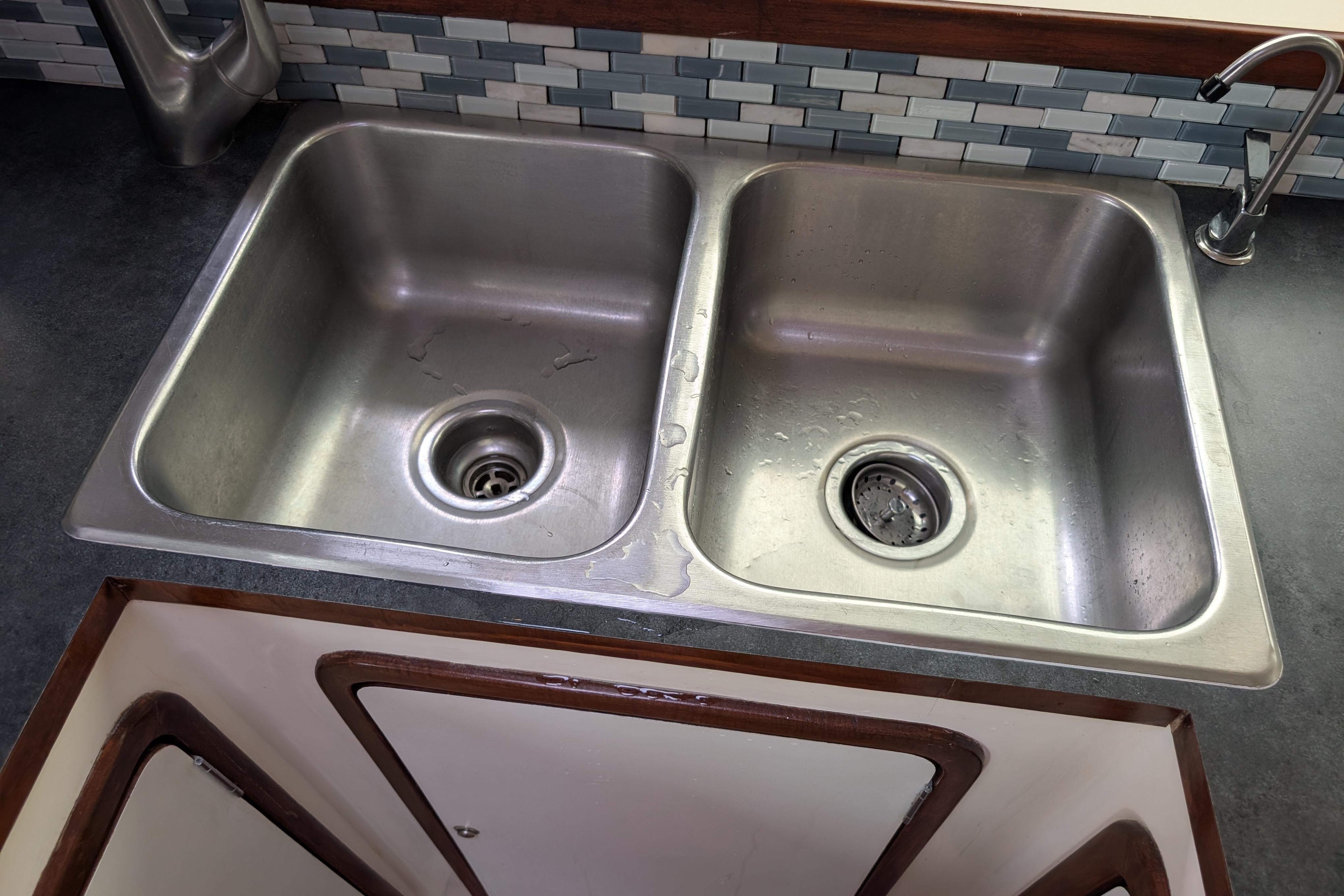 Stainless steel double sink in Island Spirit 37 yacht, 1999 model, with tiled backsplash.