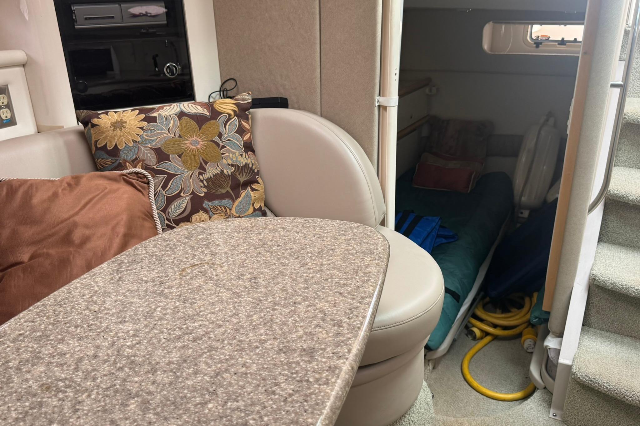 Interior of 1998 Maxum 3700 SCR boat with cozy seating and floral cushions.