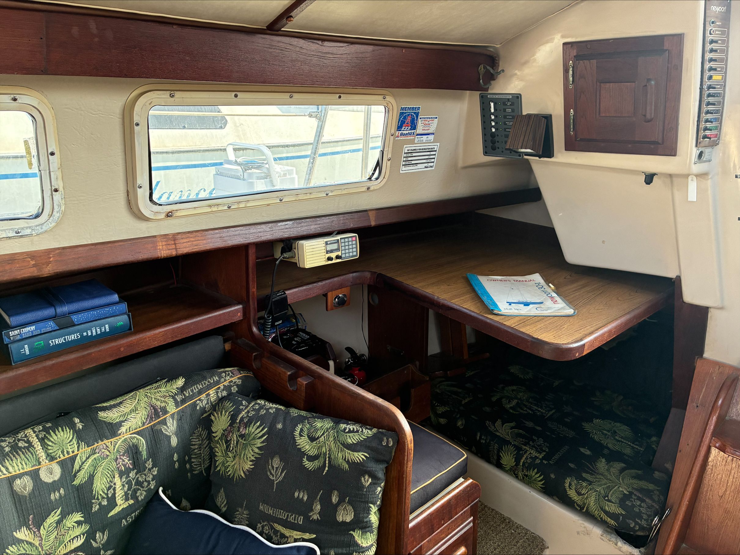 Interior of a 1980 Newport 30 with cozy seating and wooden furnishings.