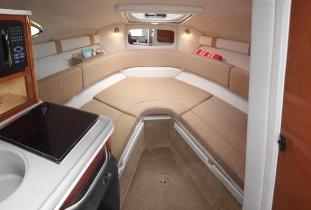 Interior of 2012 Sea Ray 240 Sundancer boat with cozy seating and kitchenette.