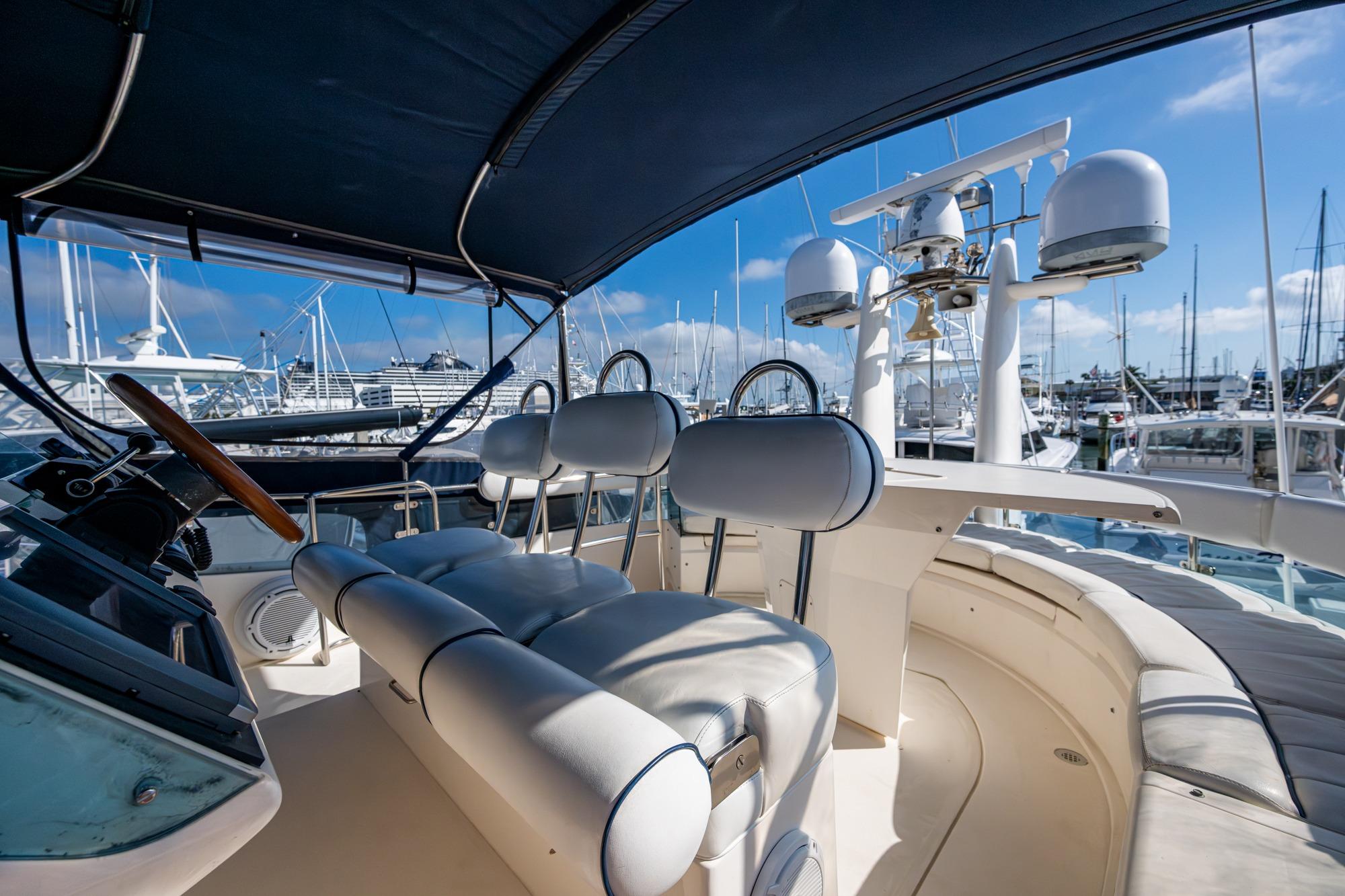 Flybridge of 2000 Fairline Squadron 52 yacht with helm and seating, docked at marina.