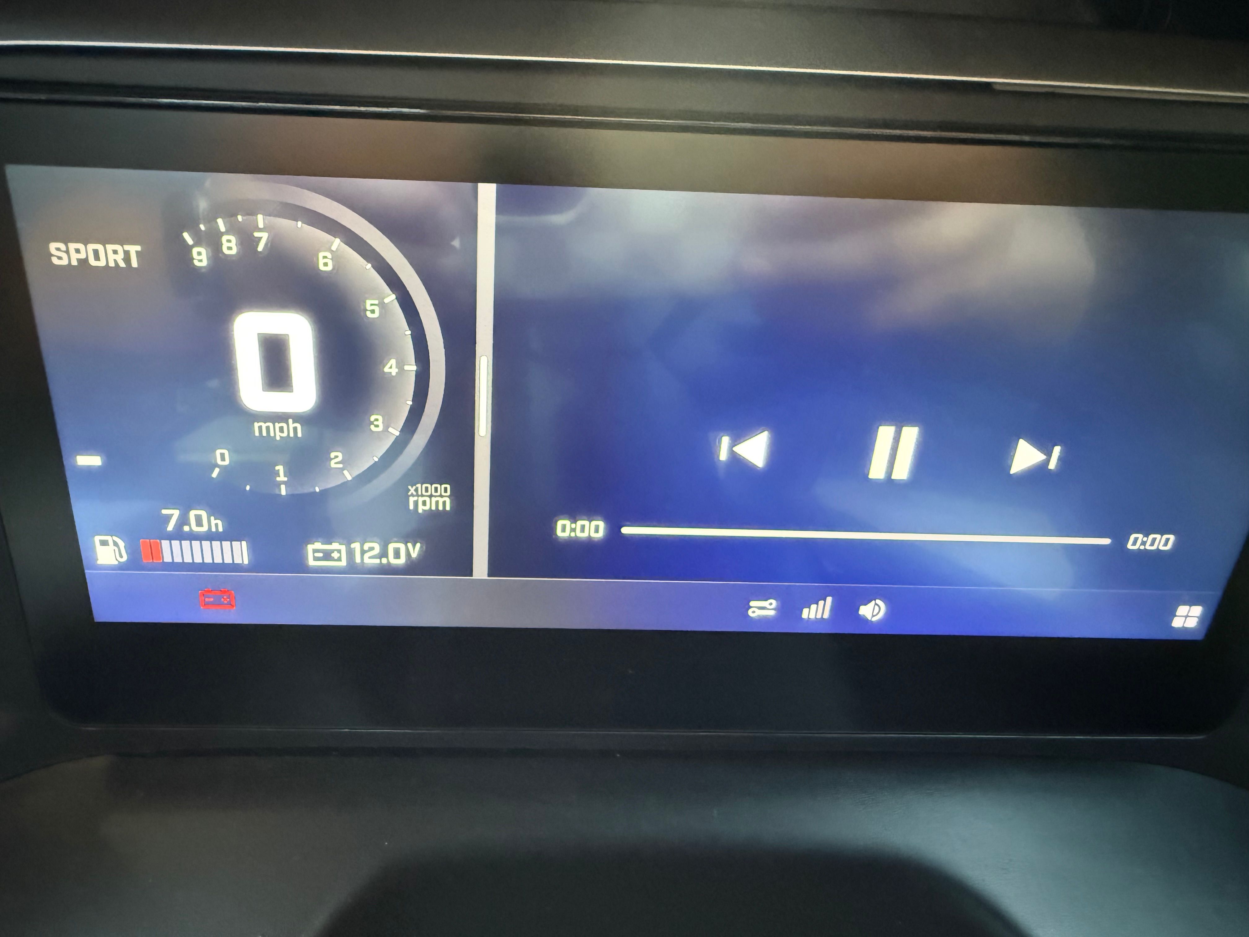 Digital dashboard with speedometer and music controls.
