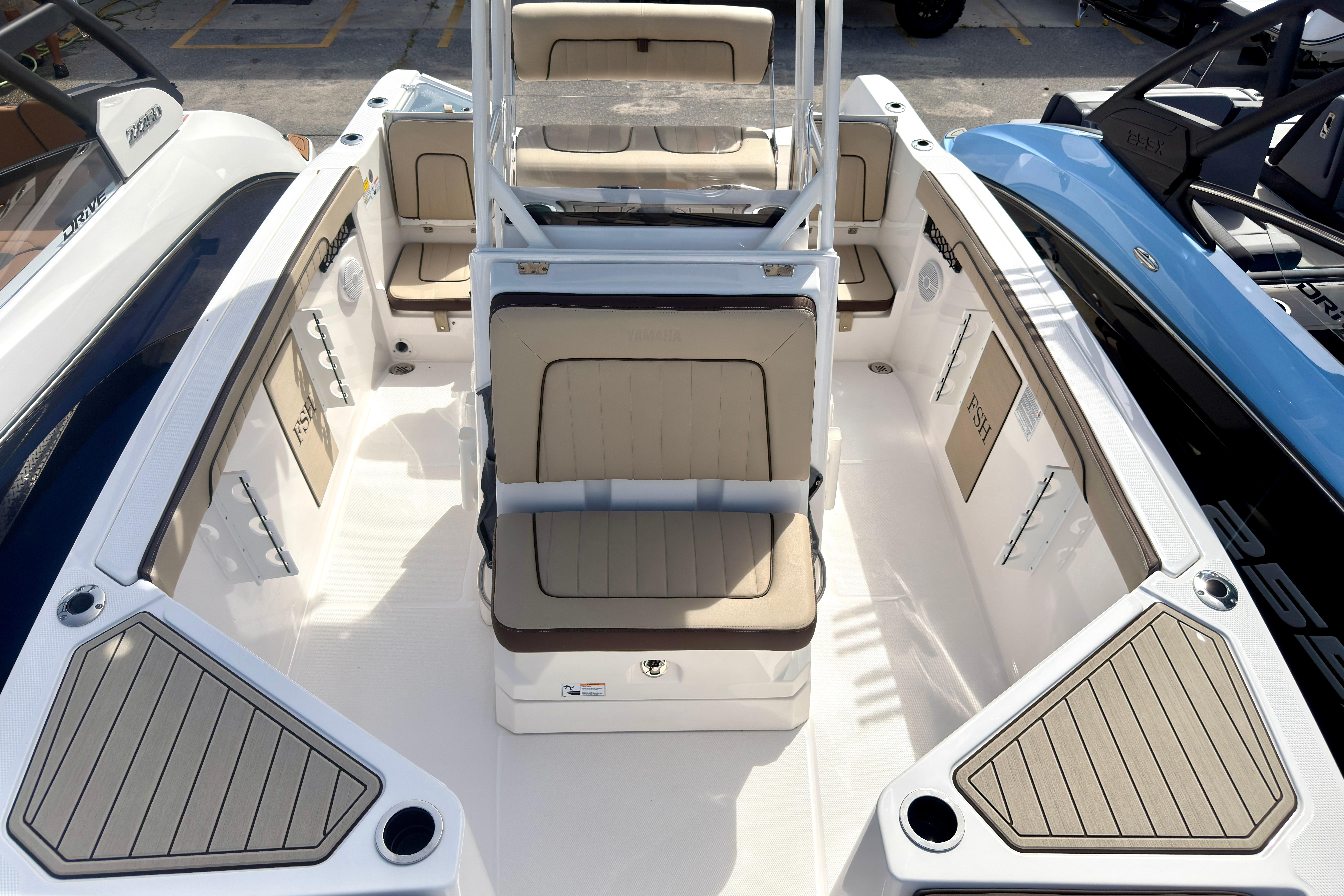 2025 Yamaha Boats 222 FSH Sport interior with beige seating and spacious deck layout.