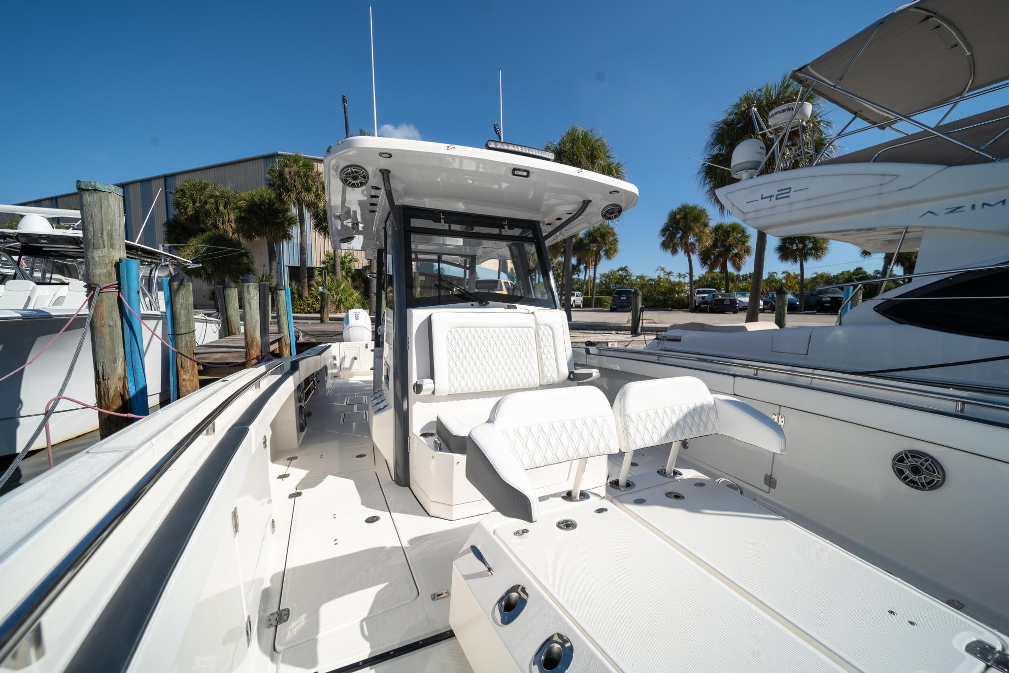 2022 World Cat 400 CC-X boat, sleek design, spacious deck, sunny marina setting.