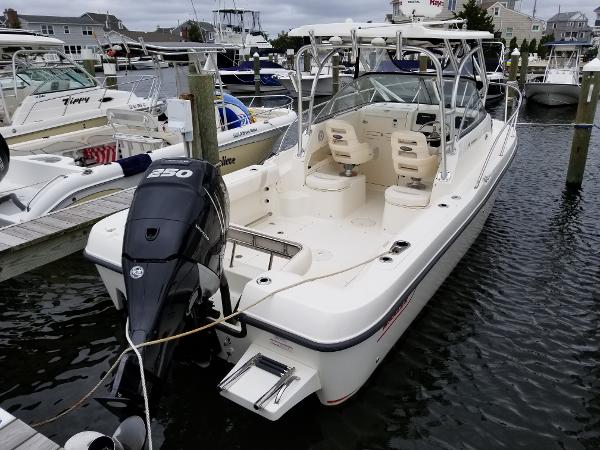 2011 Boston Whaler 235 Conquest boat docked in marina, rear view with outboard motor.