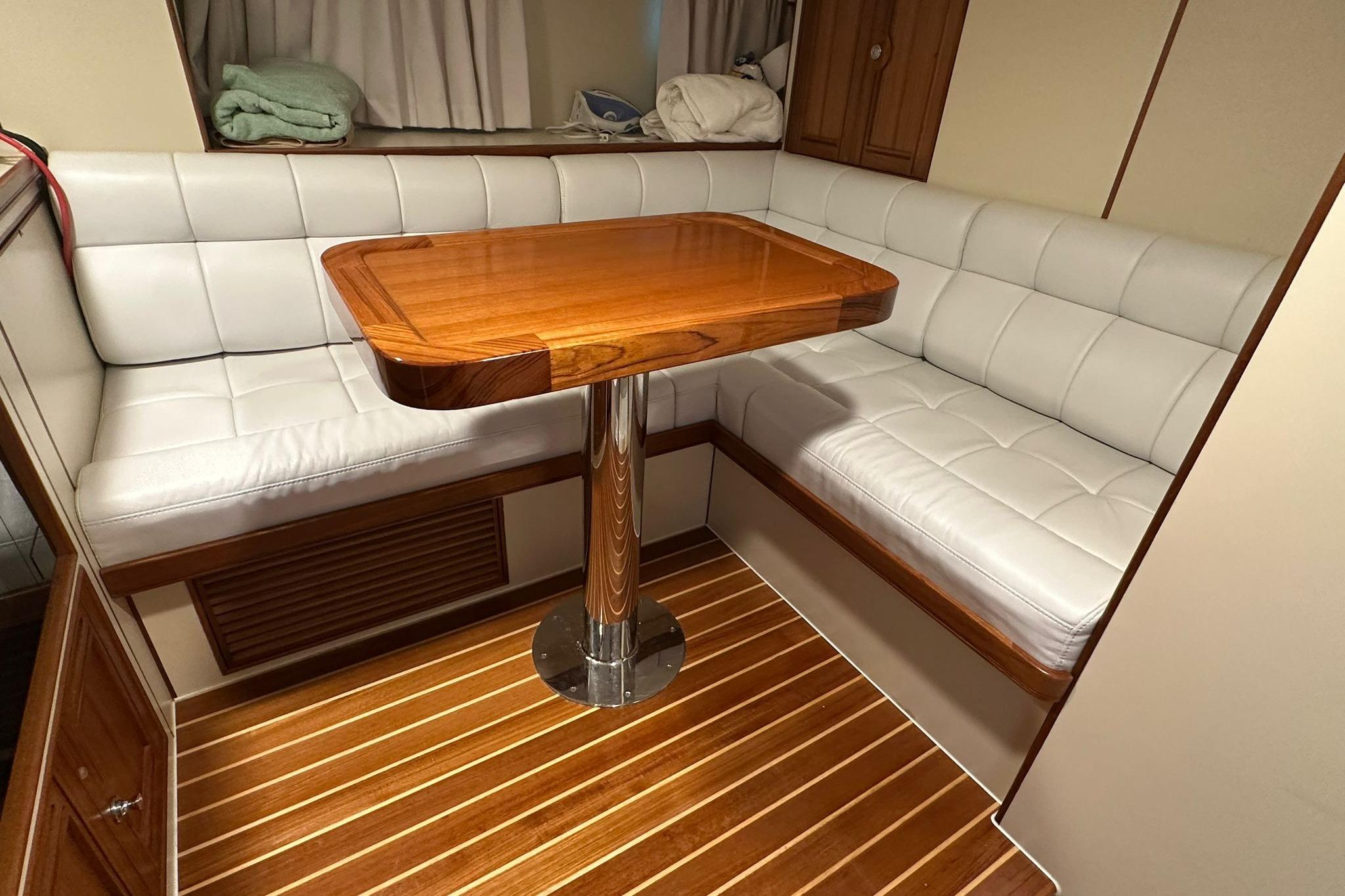 Luxurious seating area in 2023 Marlow Explorer 66E-CB with wooden table and white cushions.