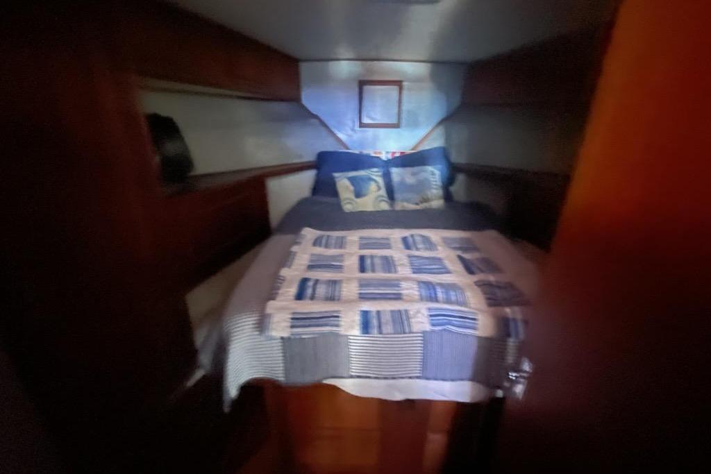 Cozy cabin interior of 1987 Topaz 44 Flybridge with bed and nautical decor.