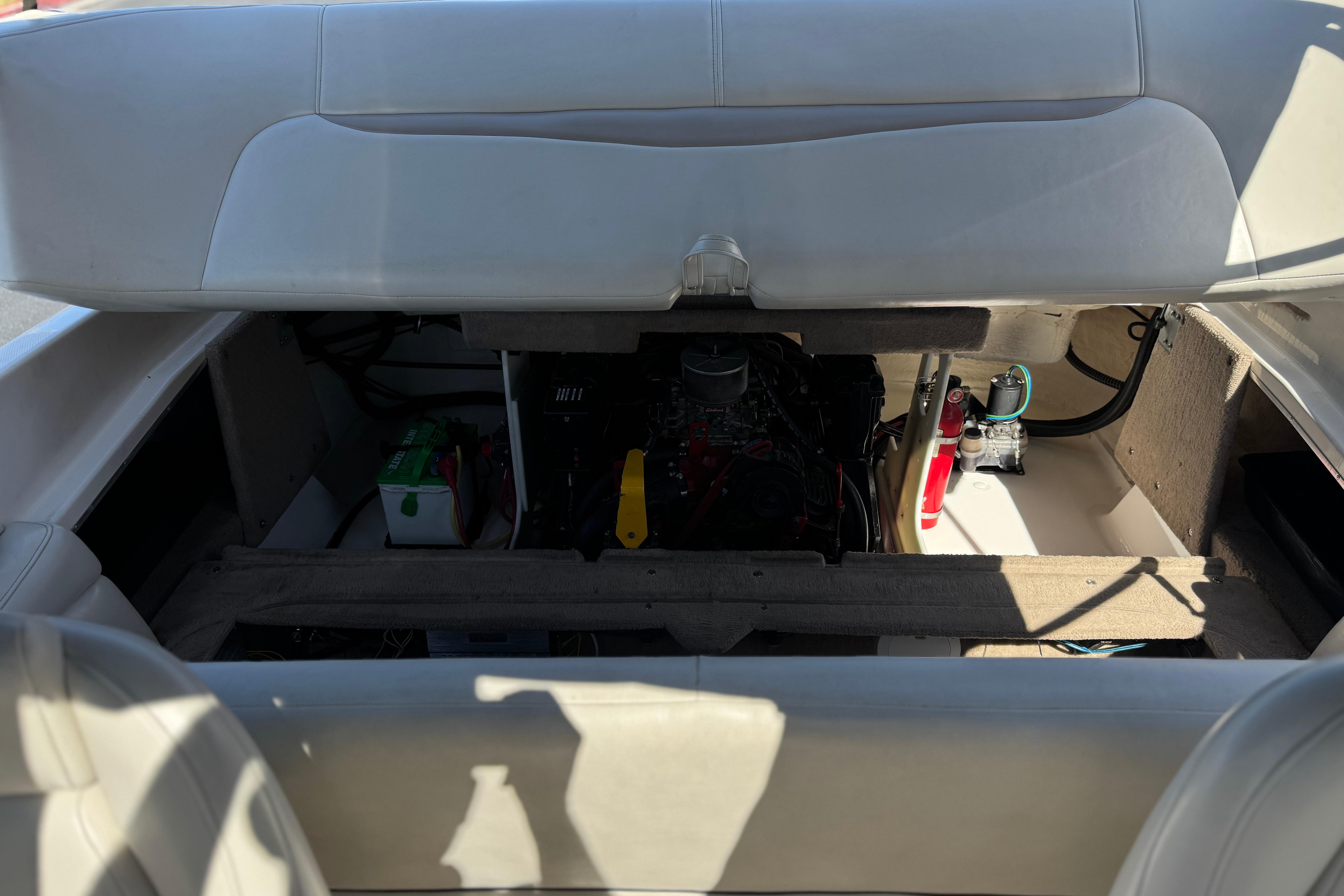 2002 Chaparral 186 SSi boat engine compartment with visible battery and fire extinguisher.