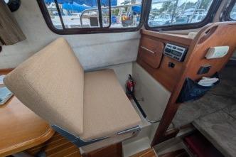 2008 Ranger 25interior with beige two-way folding seat and wooden dashboard.