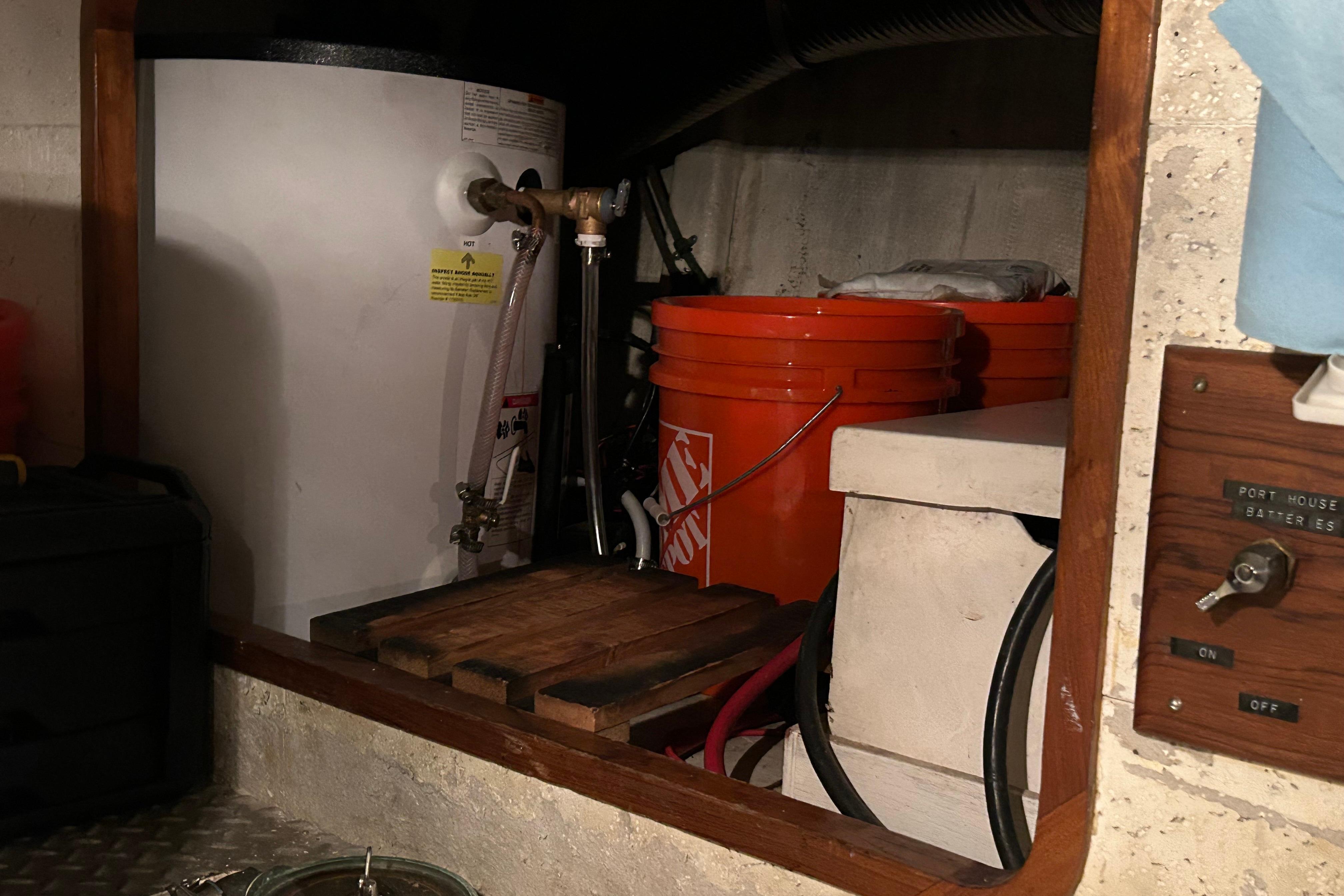 Engine room of 1981 Ocean Alexander 50 Pilothouse with water heater and storage buckets.