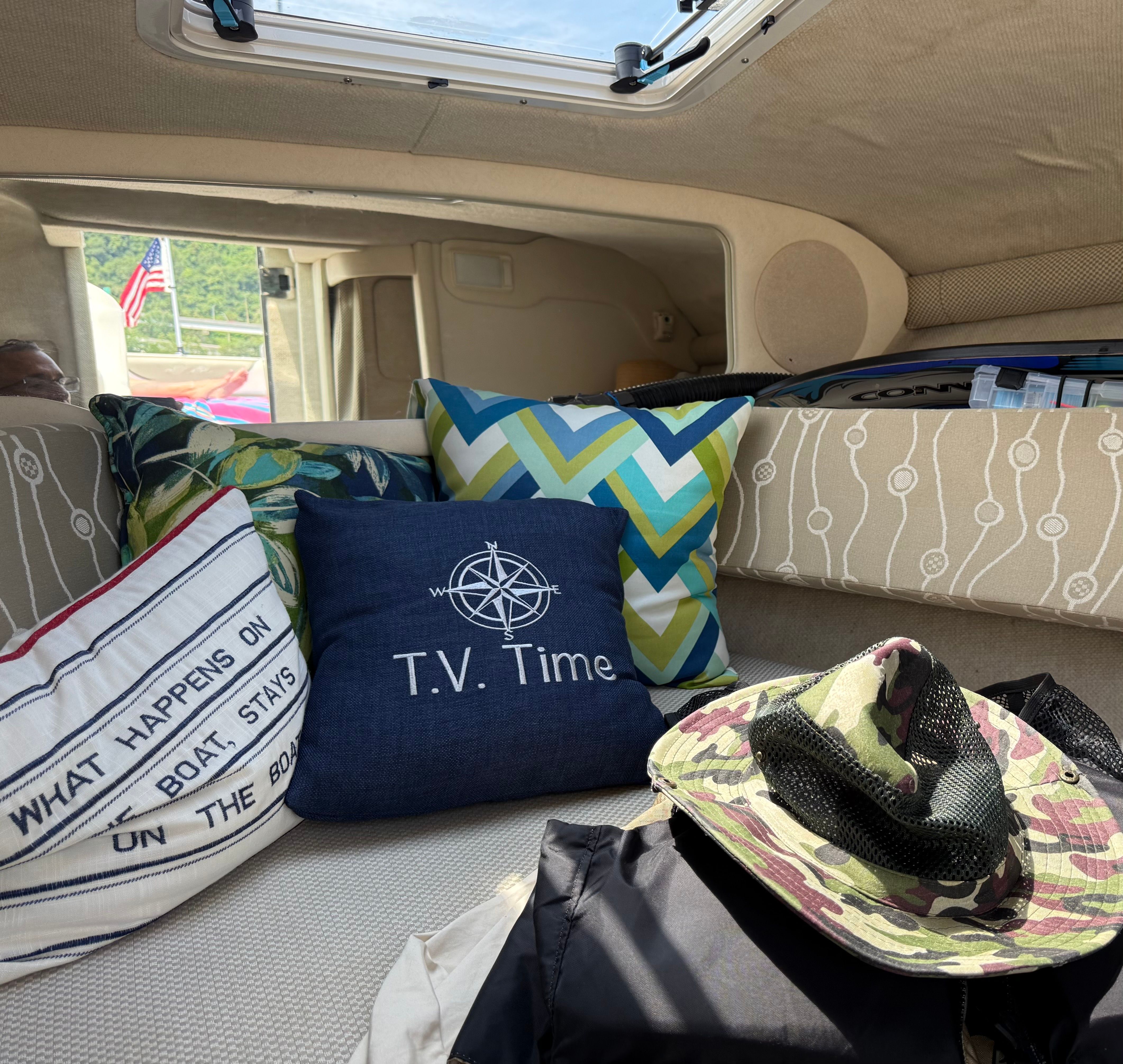Interior of a 2006 Sea Ray 215 Weekender with pillows and hat.