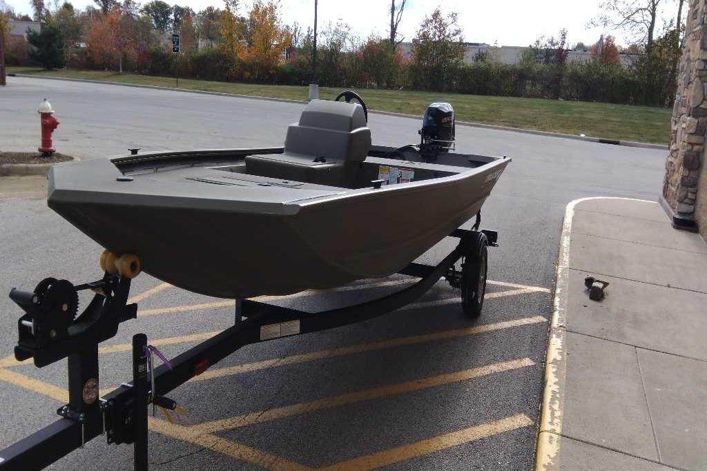 2026 Tracker Grizzly 1648 SC boat on trailer in parking lot.