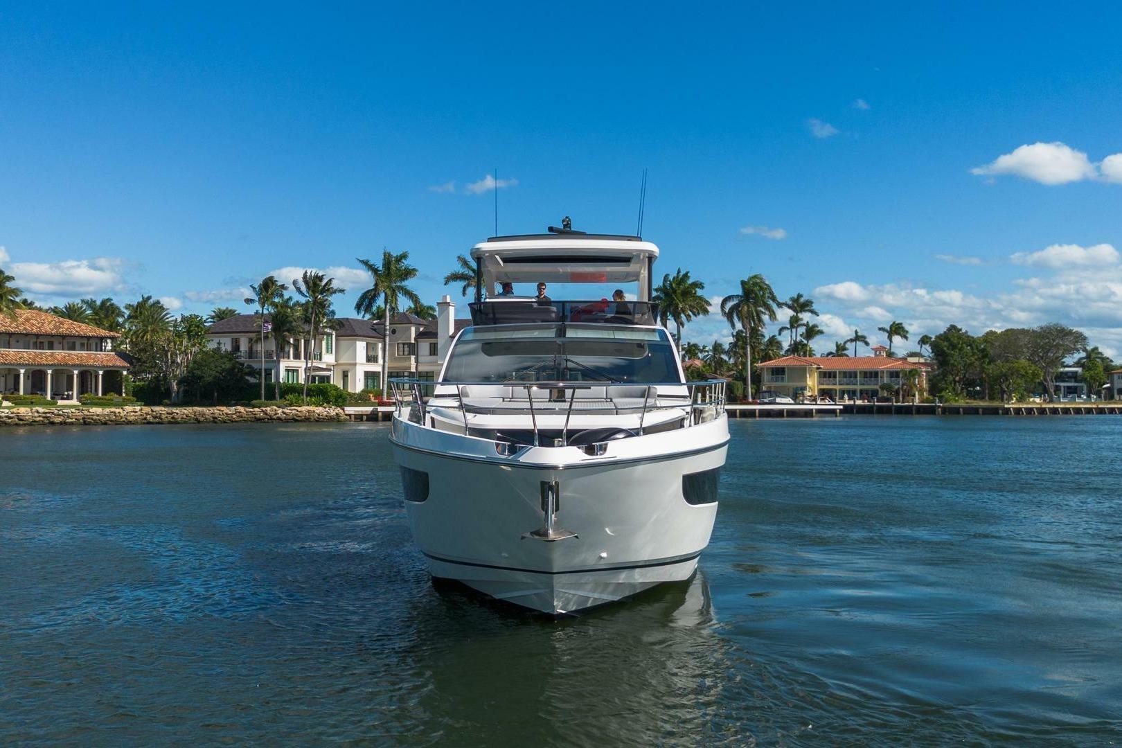 Luxury Pearl 72 yacht cruising near waterfront homes, 2023 model.