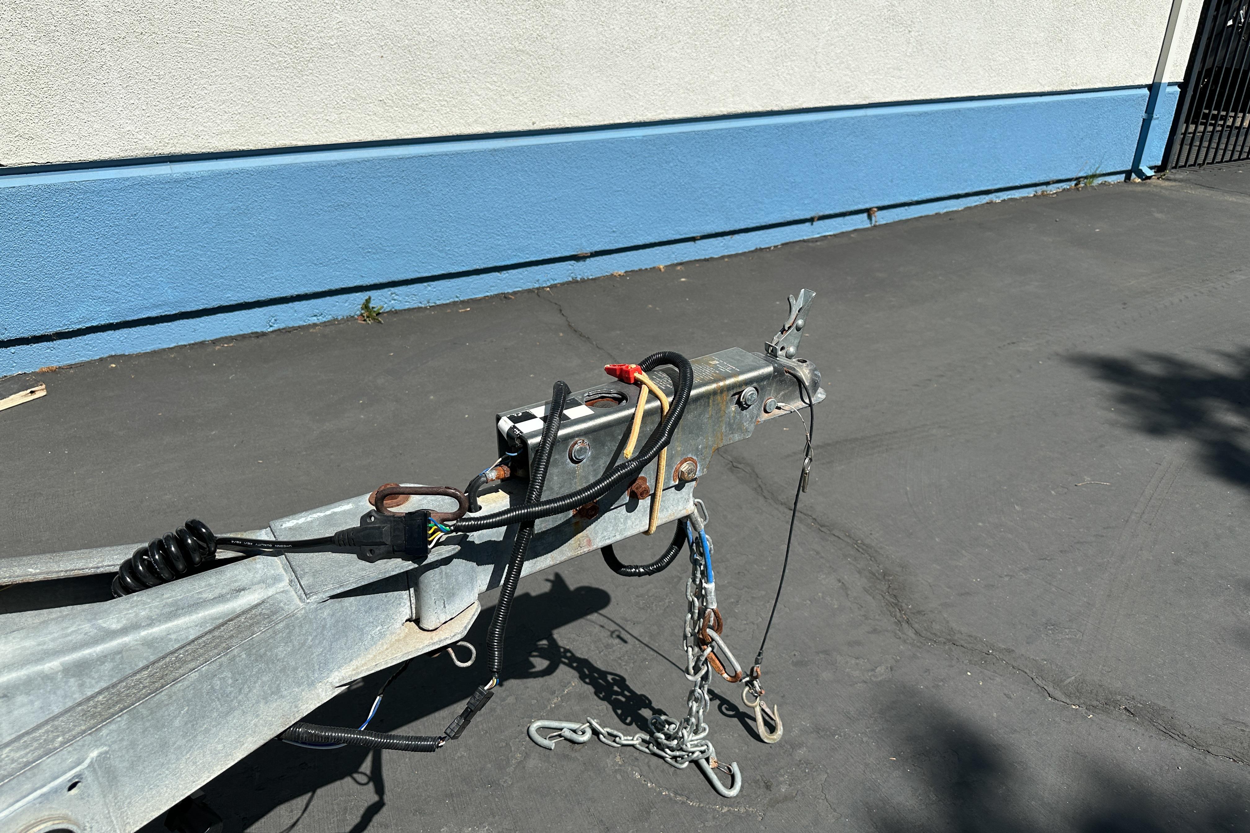 Trailer hitch of a 1998 Sea Ray 215 Express Cruiser on pavement.