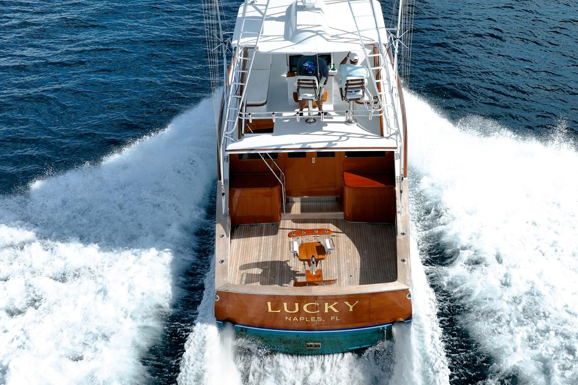 1983 Rybovich 55 Convertible yacht cruising on open water, rear view.