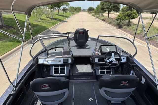 2026 Ranger 212LS boat interior with dual consoles and steering wheel, parked on a paved road.