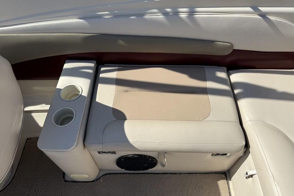 1999 Glastron GT 225 boat interior with beige seating and cup holders.