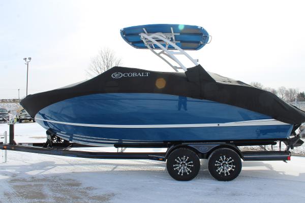 2025 Cobalt R6 boat with cover on trailer, parked in snowy area.