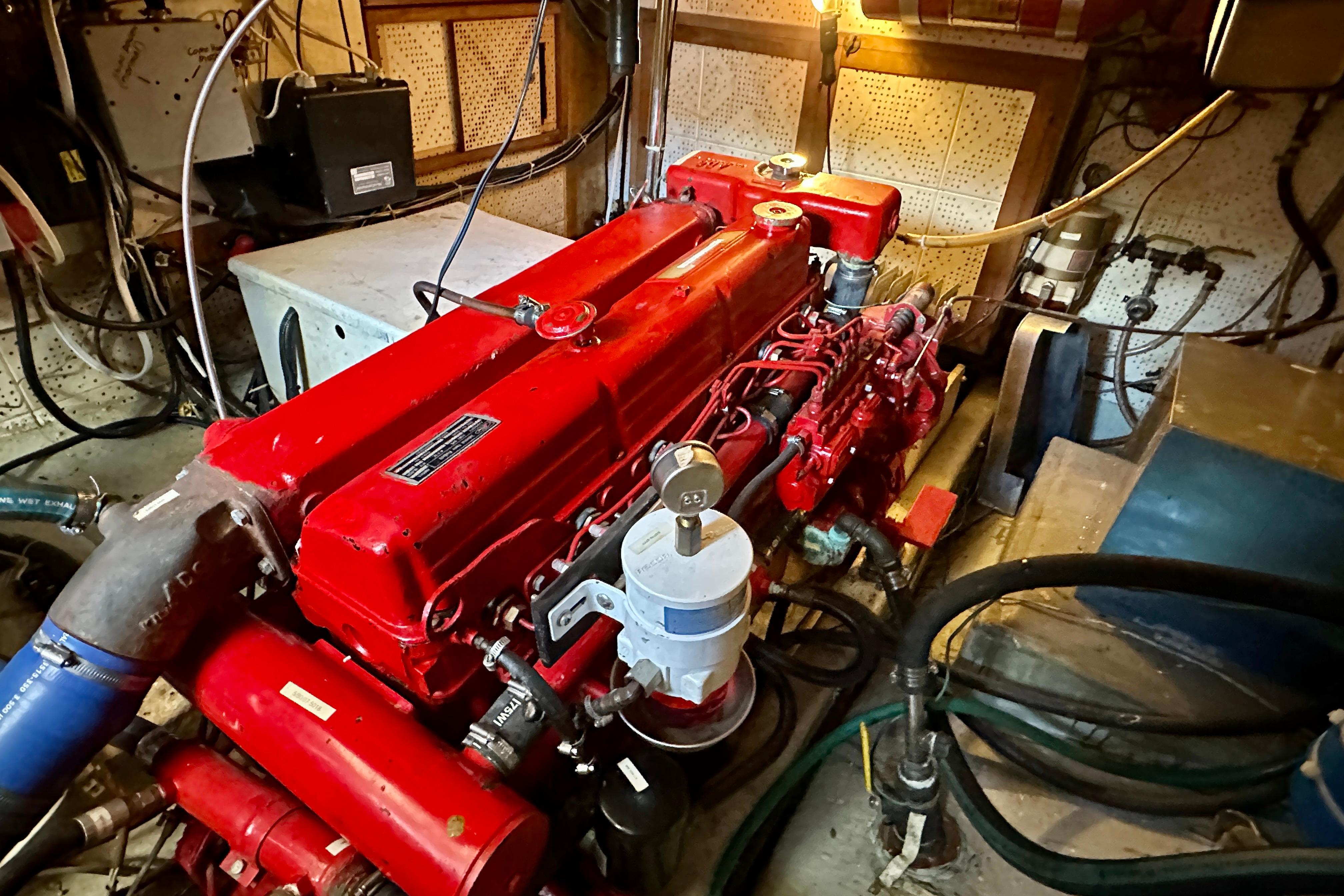 Engine room of a 1983 Kadey-Krogen Krogen 42 Trawler with a red engine.