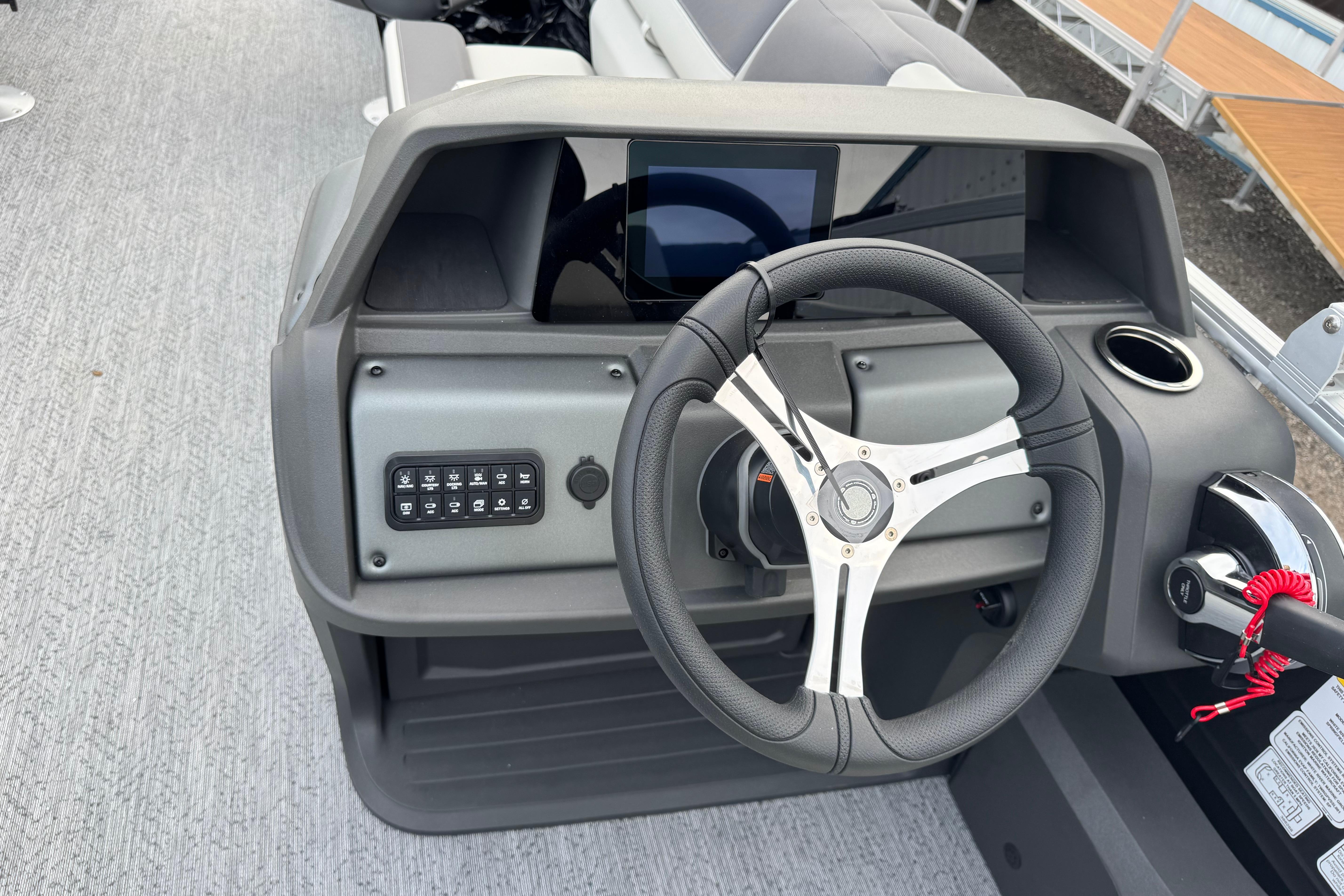 Steering console of 2026 Sun Tracker Fishin' Barge 22 DLX with modern controls.