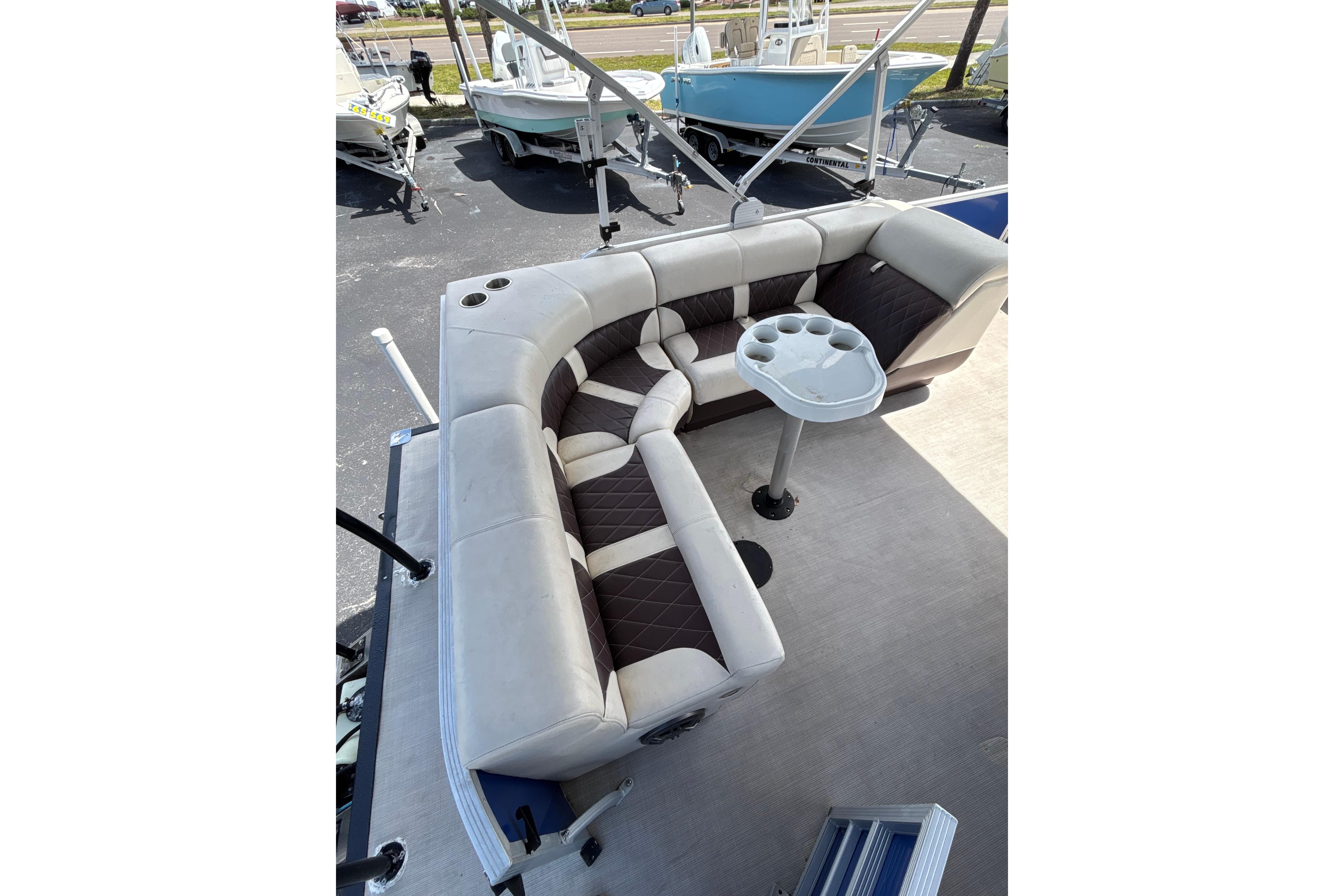 2022 Lexington 323 boat interior with cushioned seating and cup holder table.
