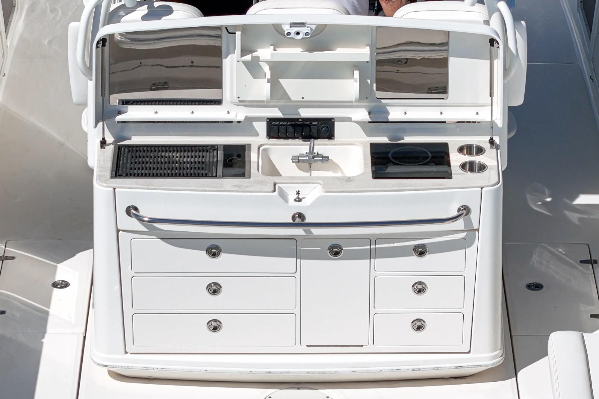 Boston Whaler 370 Outrage 2015 boat kitchen with sink, grill, and storage drawers.
