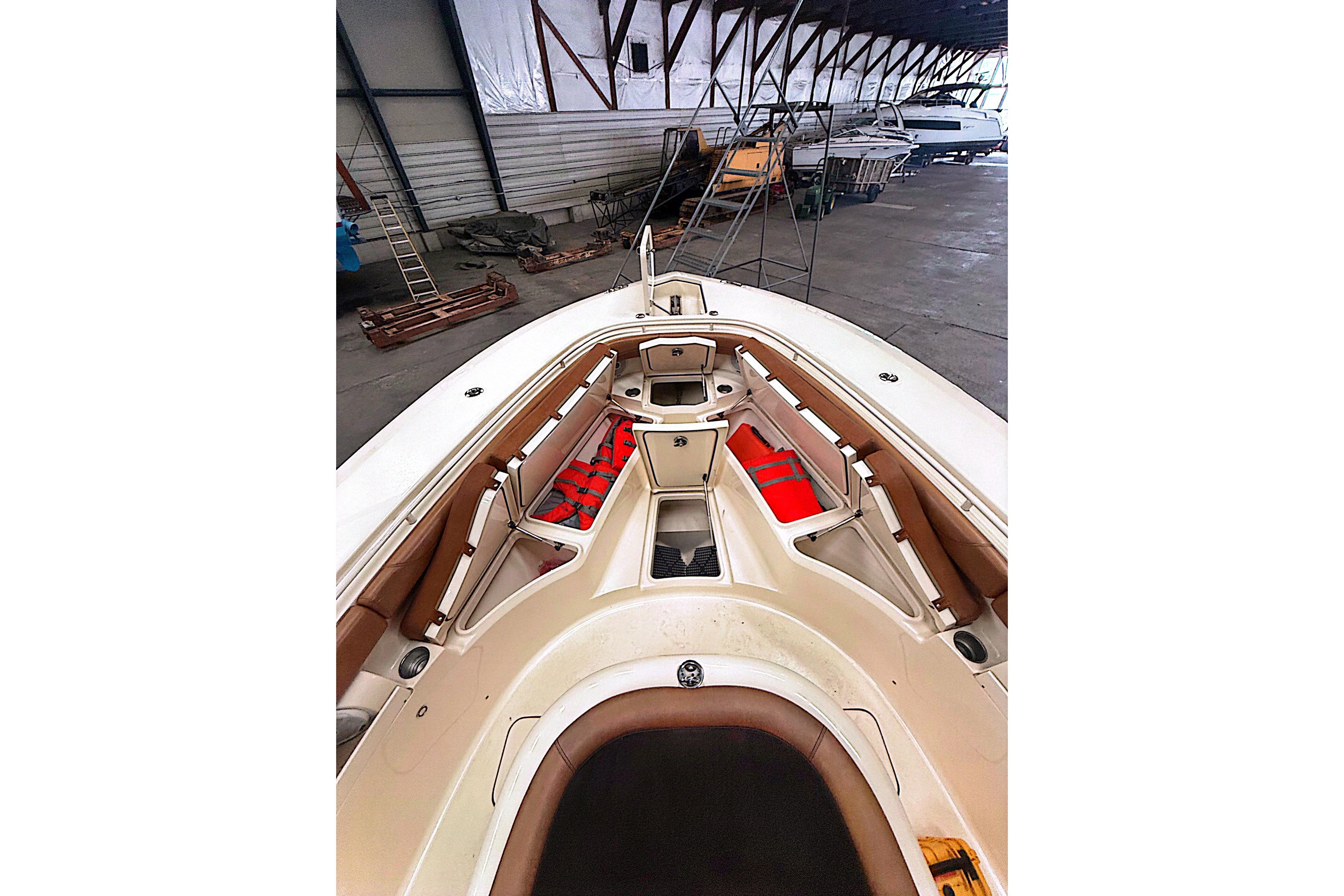 2016 Scout 350 LXF boat interior with seating and storage in a warehouse.