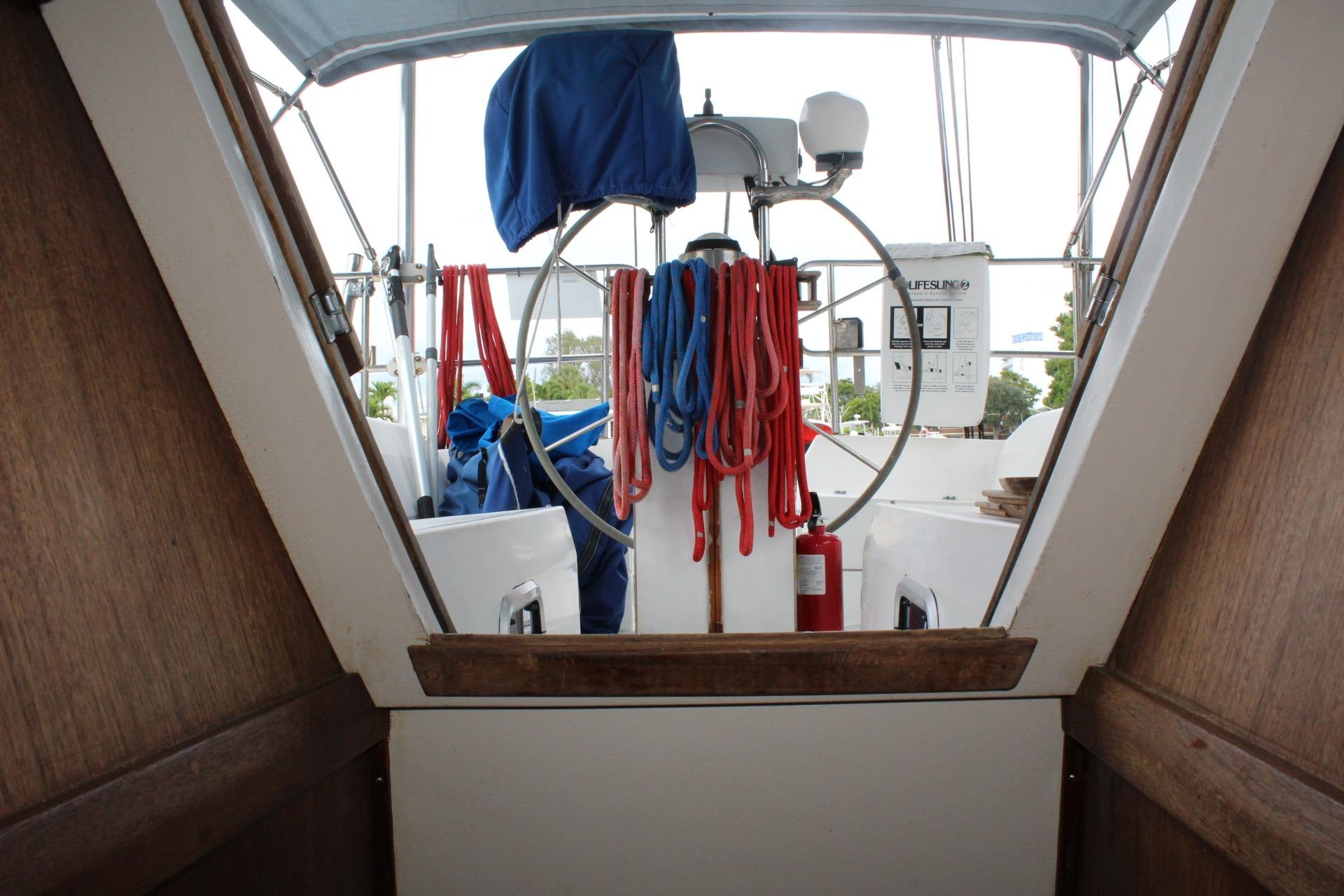 Cockpit view of 1989 Catalina 42 sailboat with ropes and steering wheel.