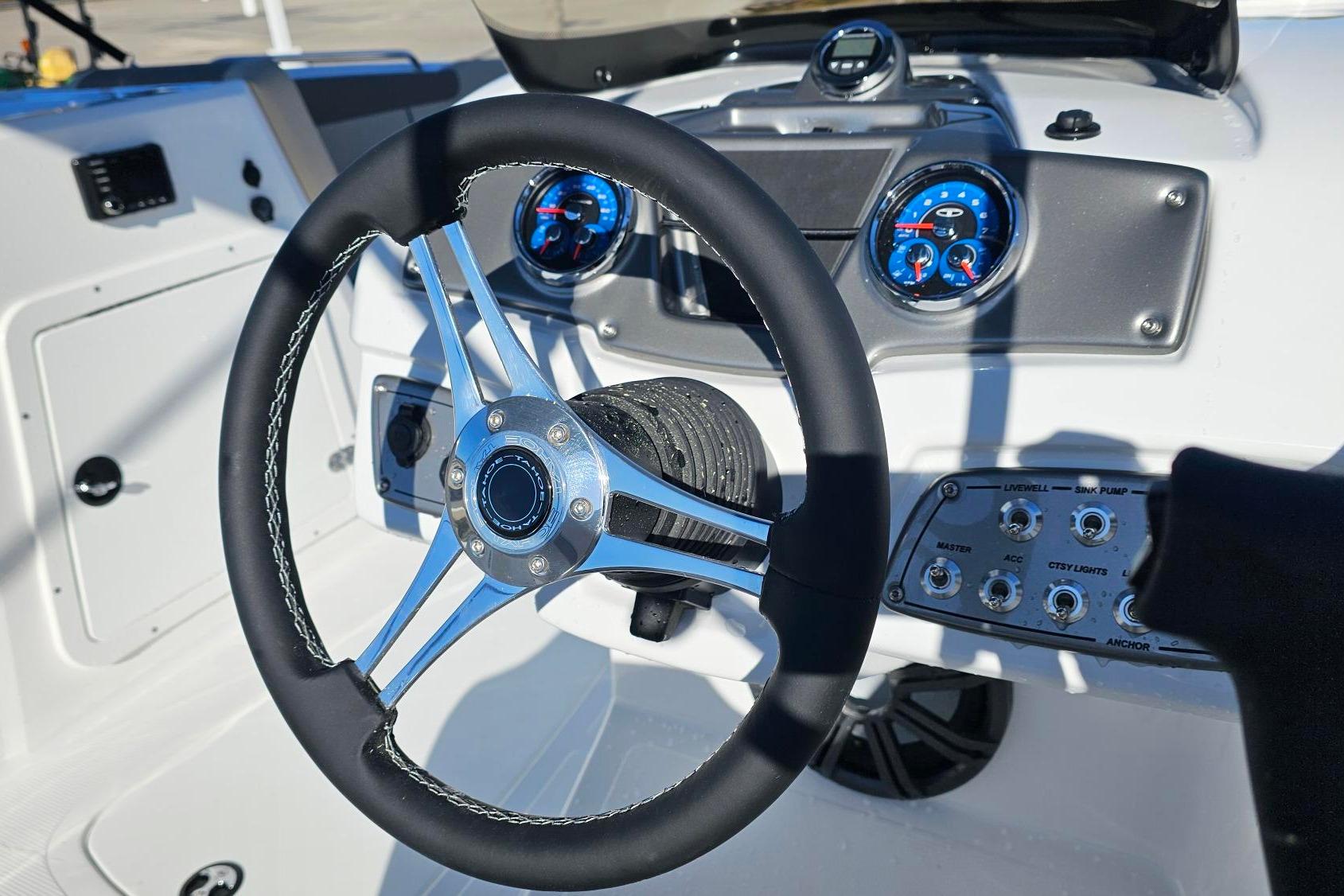 Steering wheel and dashboard of 2026 Tahoe 2150 boat, featuring modern controls and gauges.