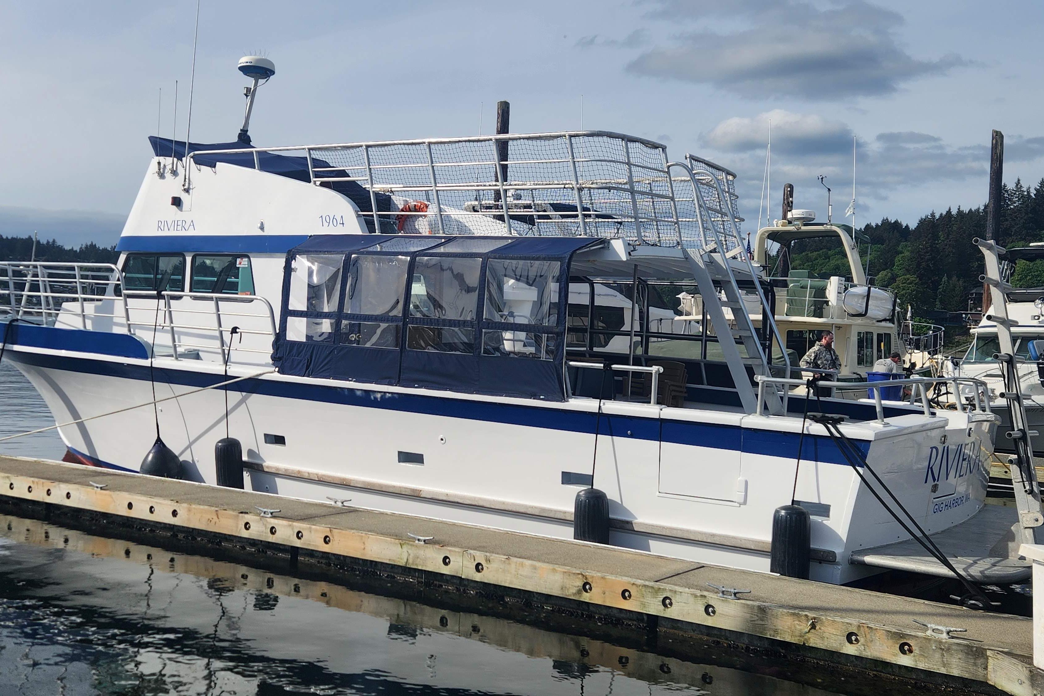 1964 Grandy Tour Boat docked at marina, featuring blue and white design.