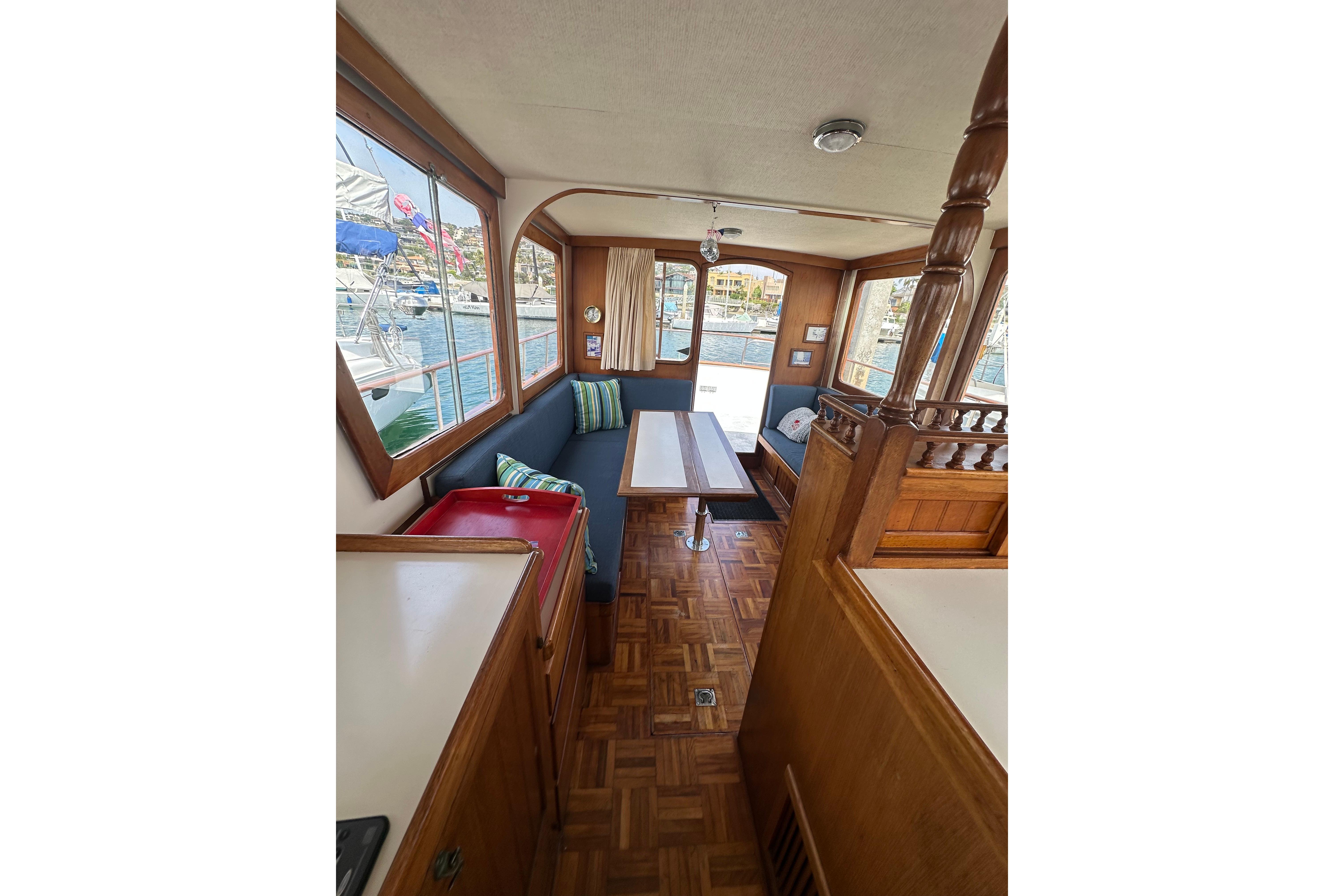 Interior of a 1973 CHB 33 boat with wooden furnishings and a cozy seating area.