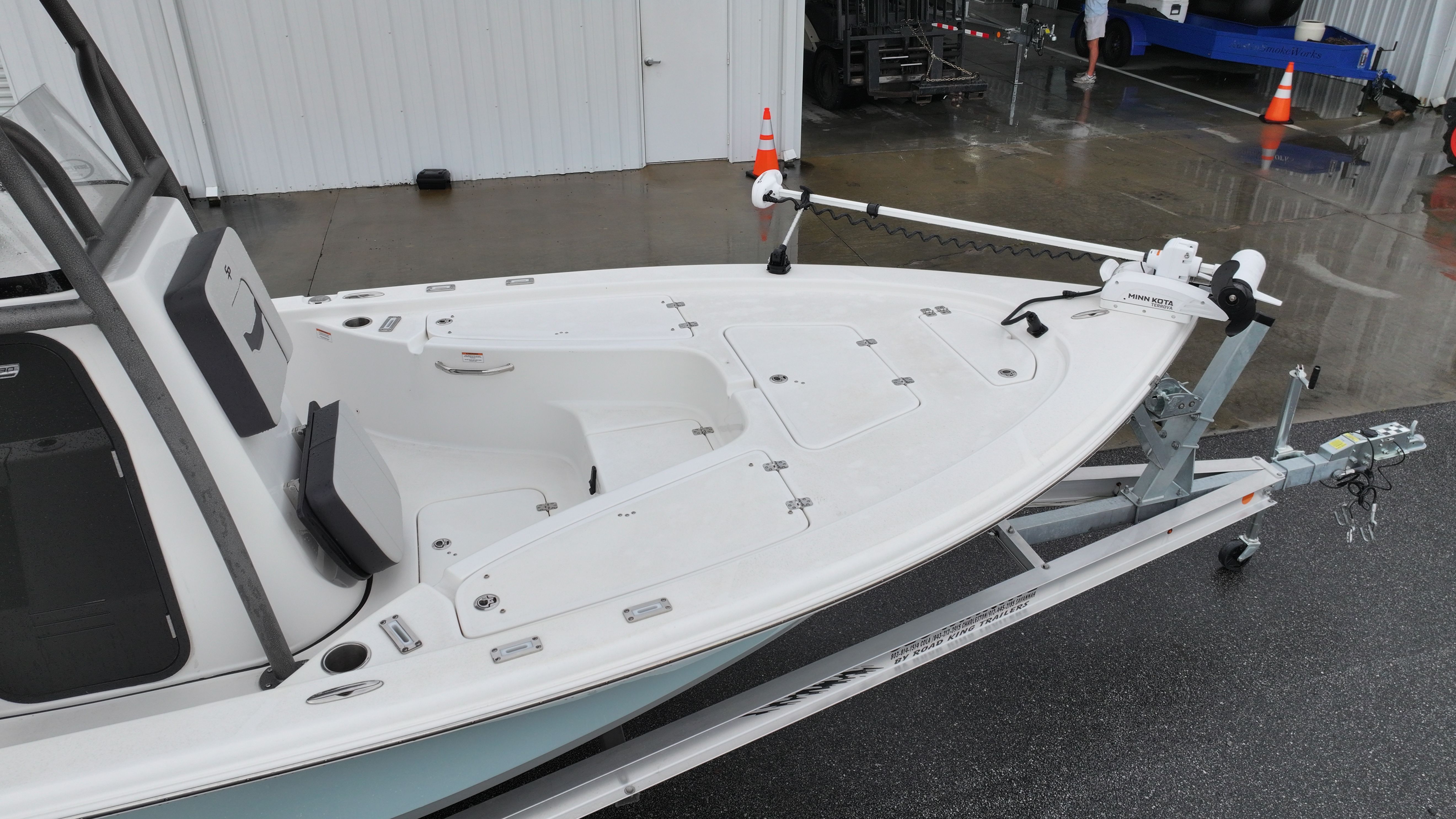 A Sea Pro 230 DLX boat on a trailer, ready for use.