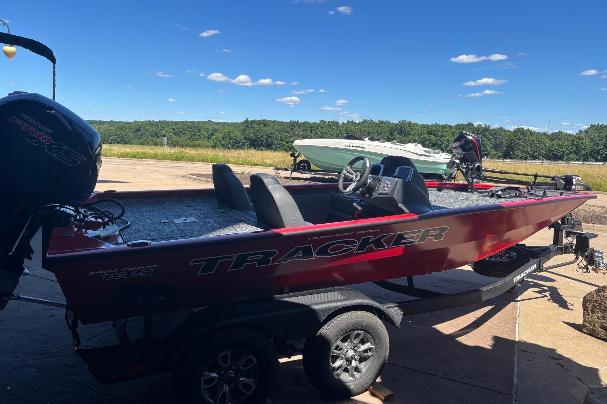 2026 Tracker Pro Team 195 boat on trailer, parked outdoors under clear blue sky.