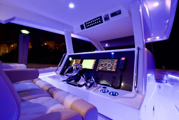 Luxurious 2019 Altima 38 Xcape boat cockpit with illuminated controls and plush seating.