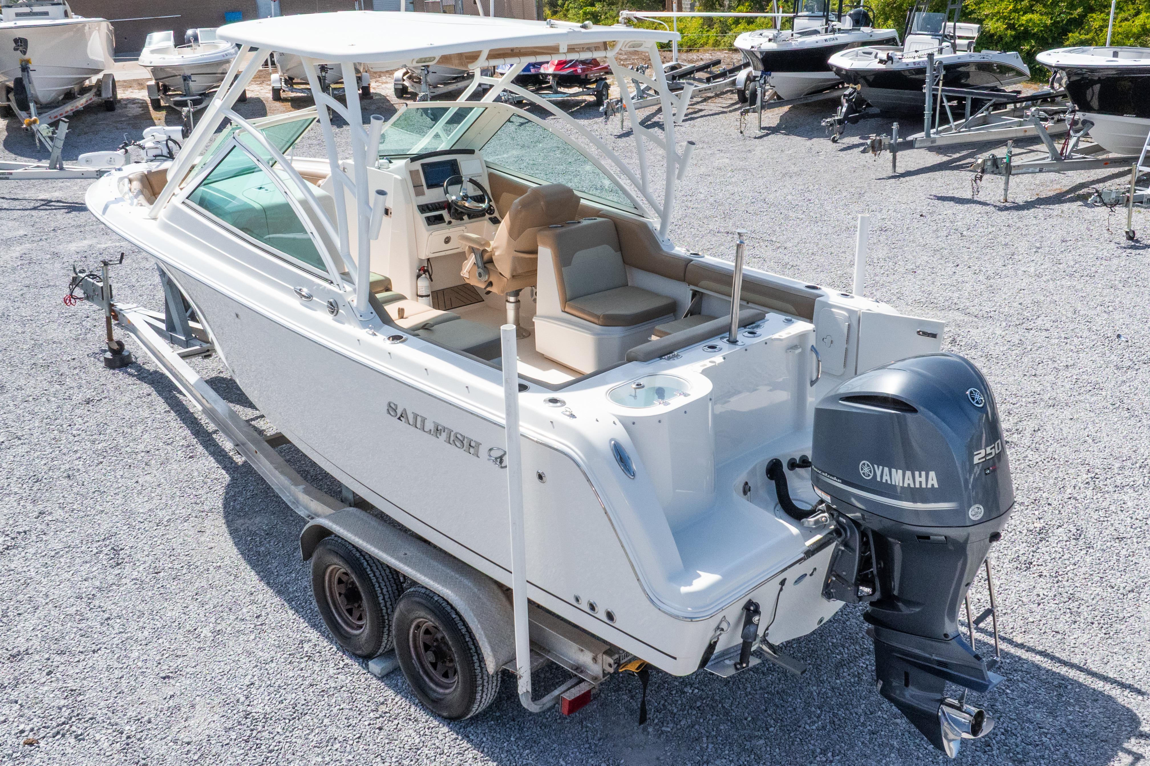 2018 Sailfish 245 DC boat with Yamaha engine on trailer in a boatyard.