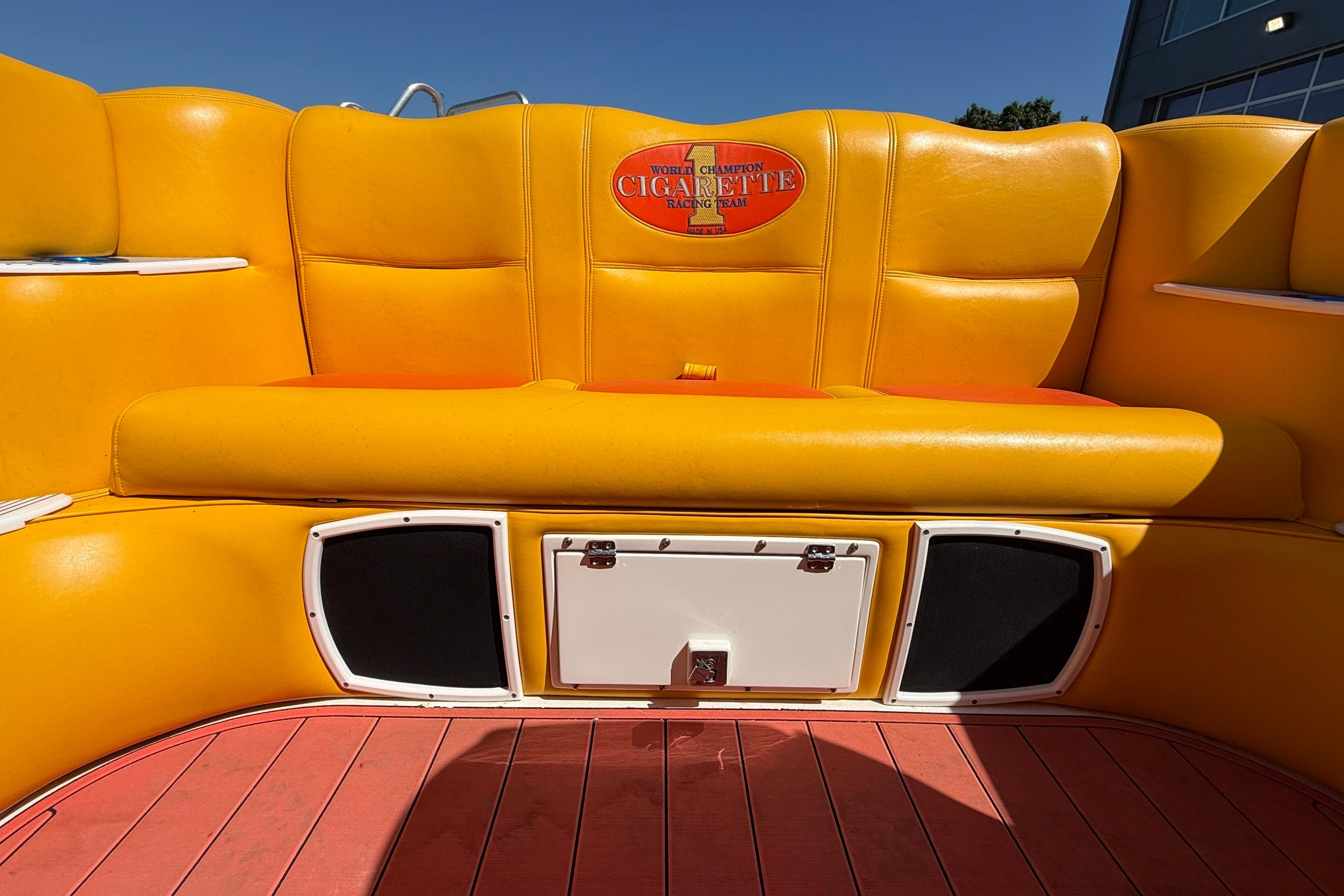 Yellow seating on a 2002 Cigarette 35' Cafe Racer boat, featuring branded upholstery.