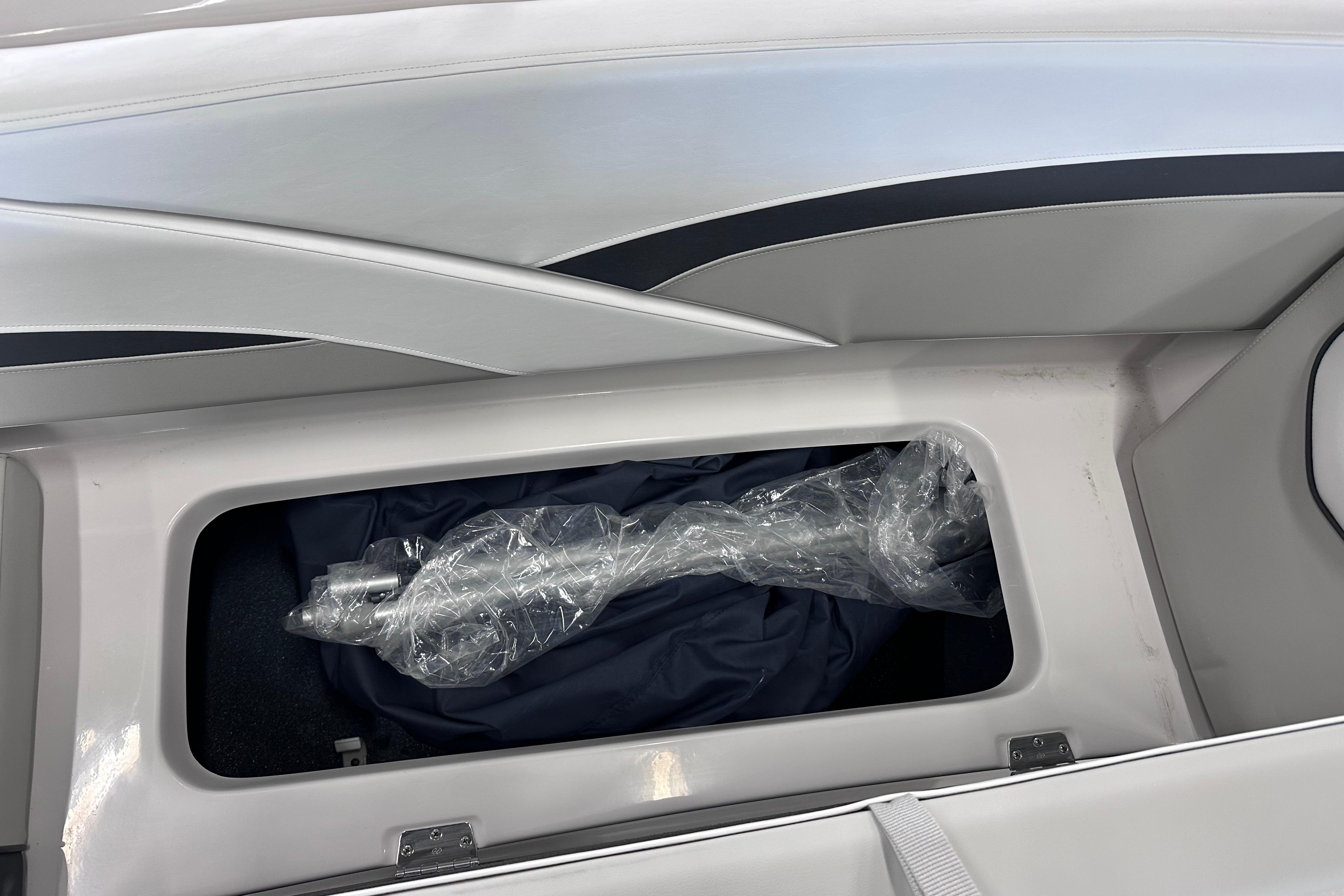 2026 Starcraft SVX 191 OB boat storage compartment with wrapped equipment inside.