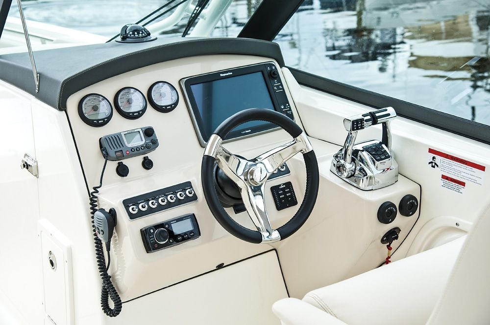The cockpit of a Boston Whaler 270 Vantage with steering wheel, instruments, and controls.
