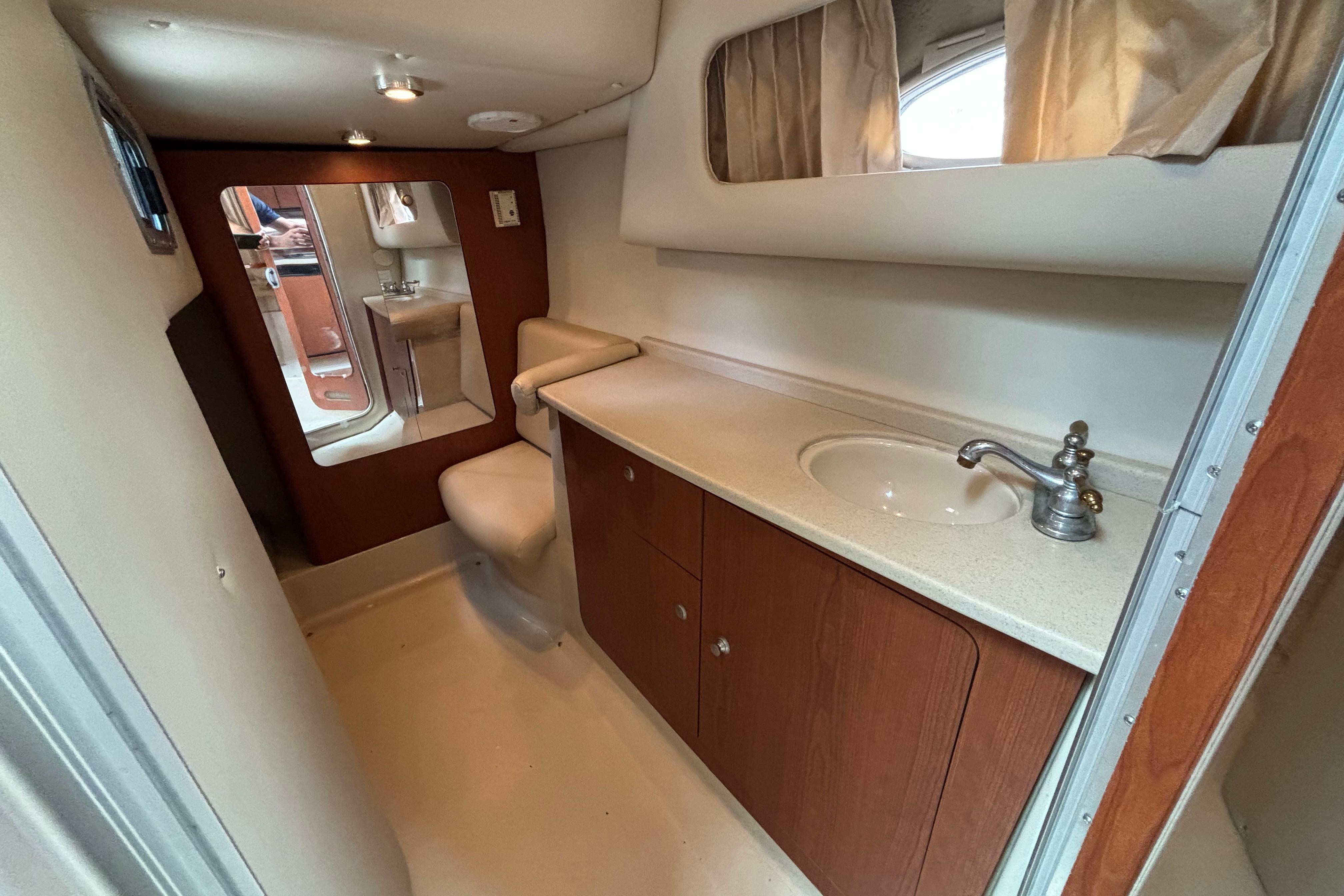 2004 Chaparral Signature 330 bathroom interior with sink, mirror, and wooden cabinetry.