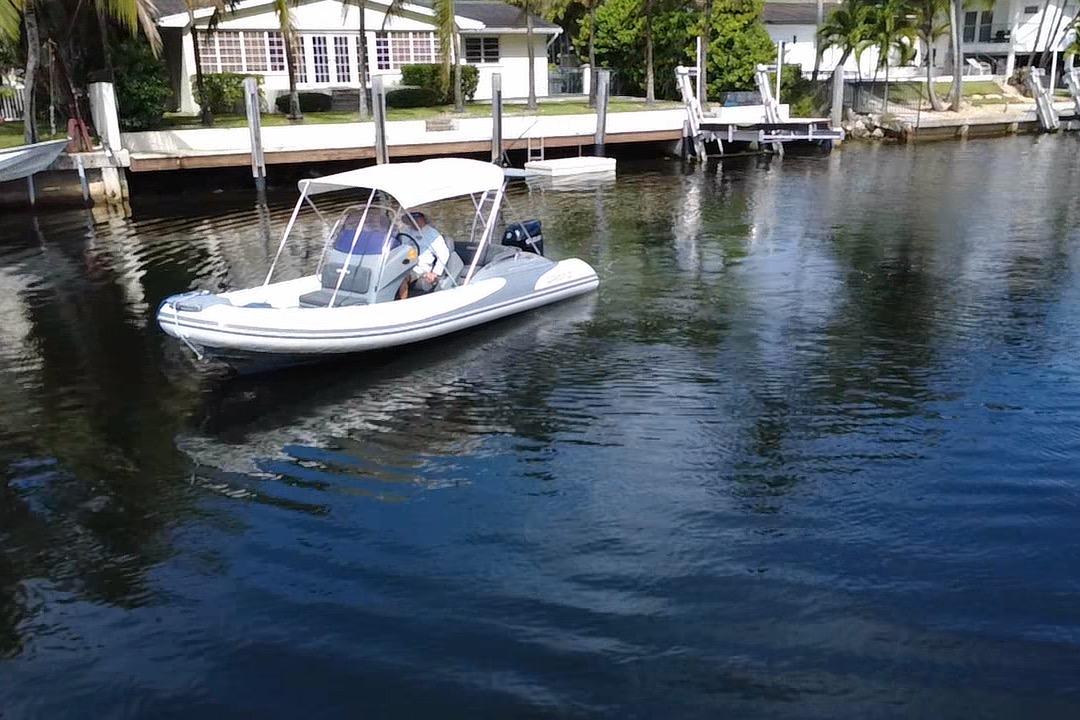 2020 Grand Inflatables G580 boat on calm water near residential docks.