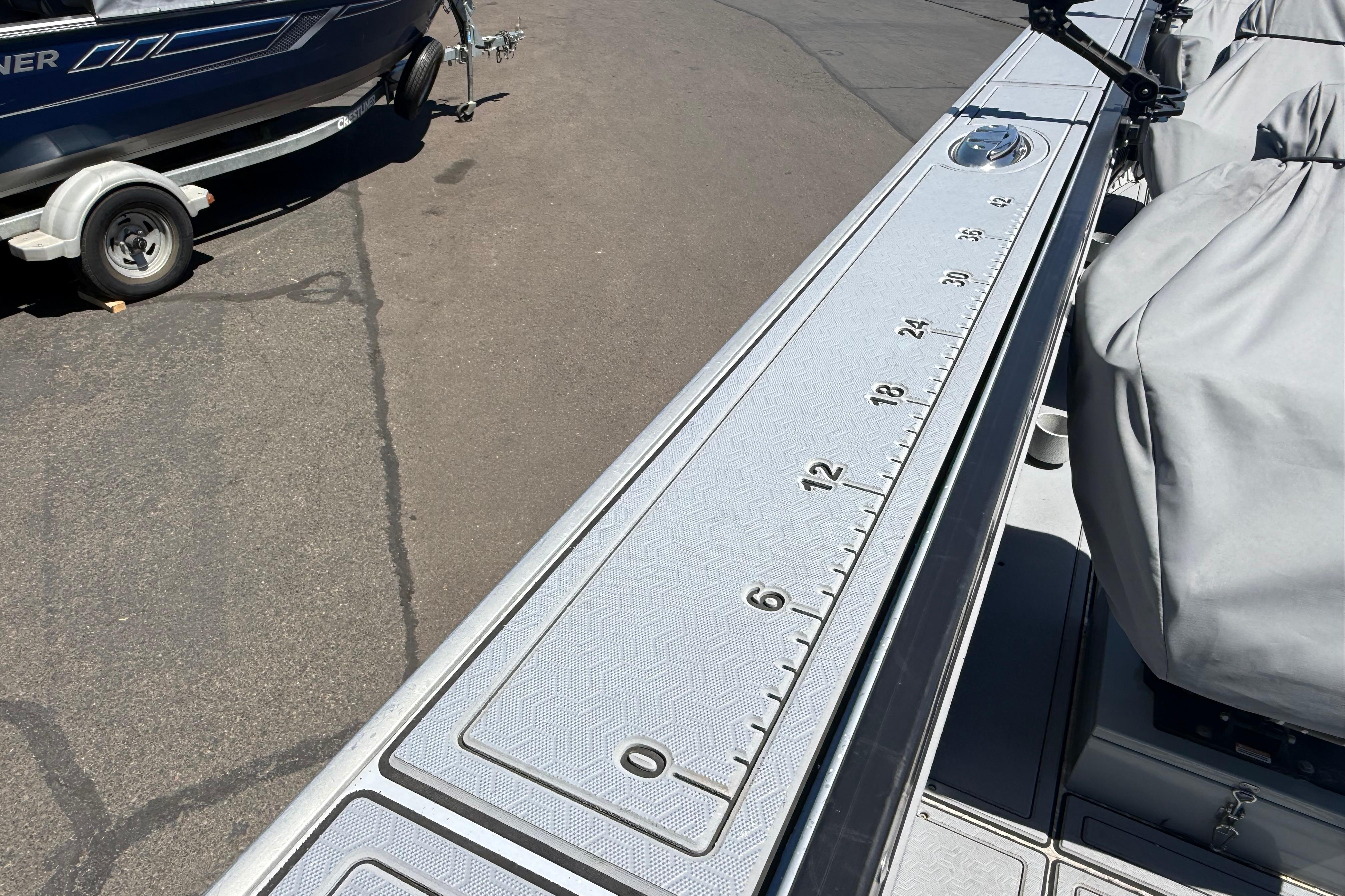 2015 Alumaweld Pacific XD 28 boat deck with measurement markings, parked on a trailer.