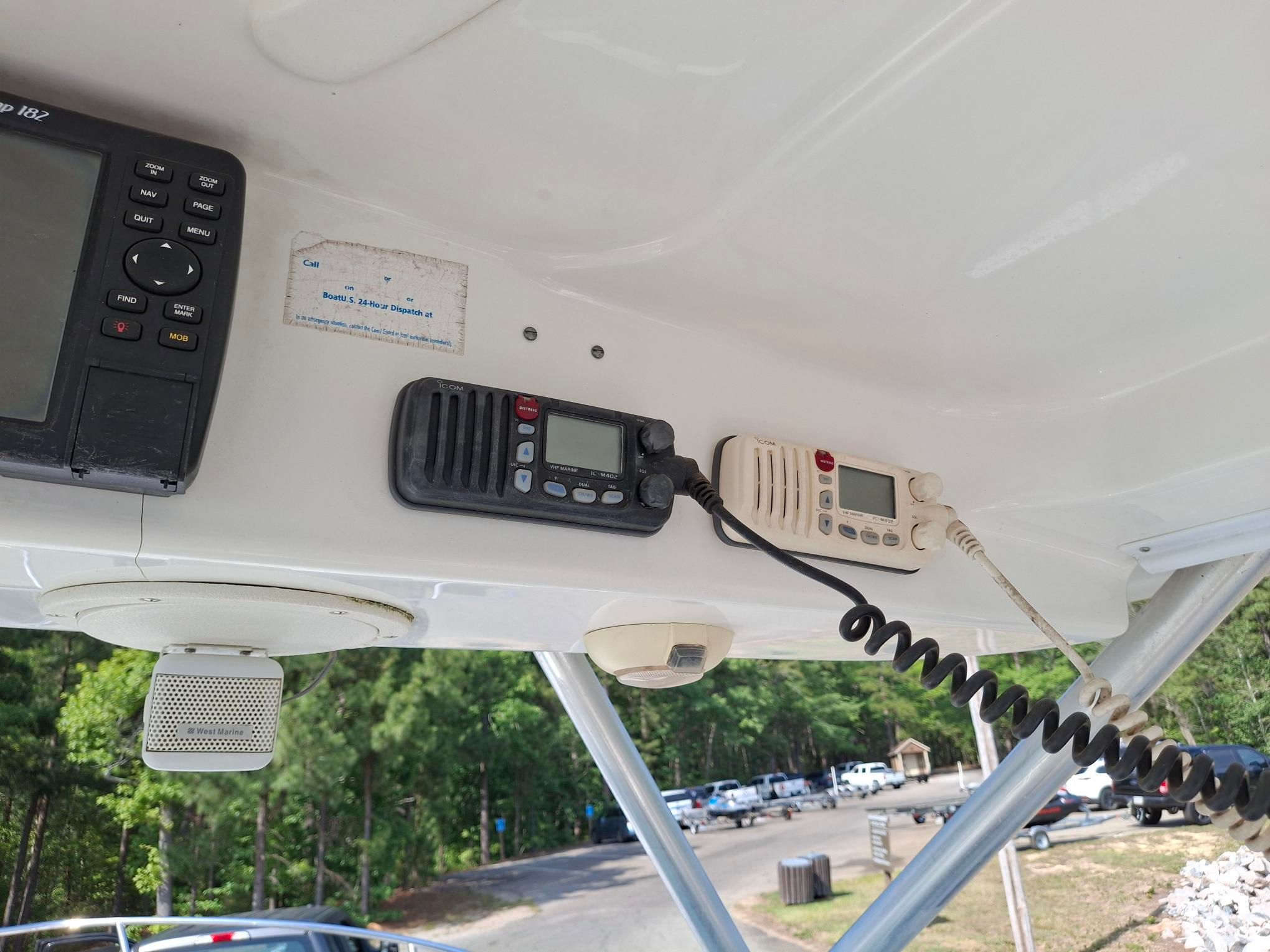 Electronic devices and speakers on a boat with a view of a parking lot.