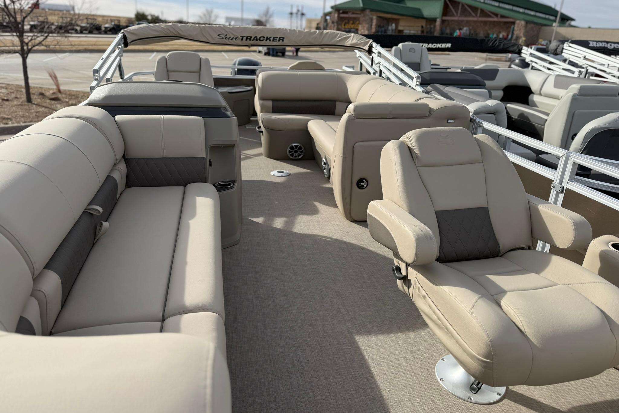 2025 Sun Tracker SportFish 20 DLX pontoon boat interior with beige seating and spacious layout.