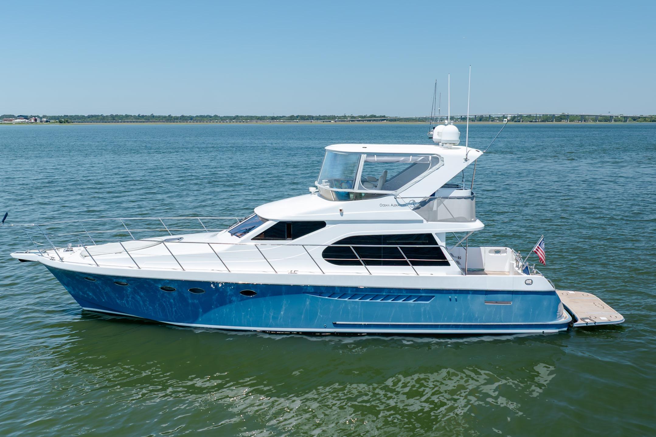 Ocean Alexander yacht cruising on calm waters under a clear blue sky.
