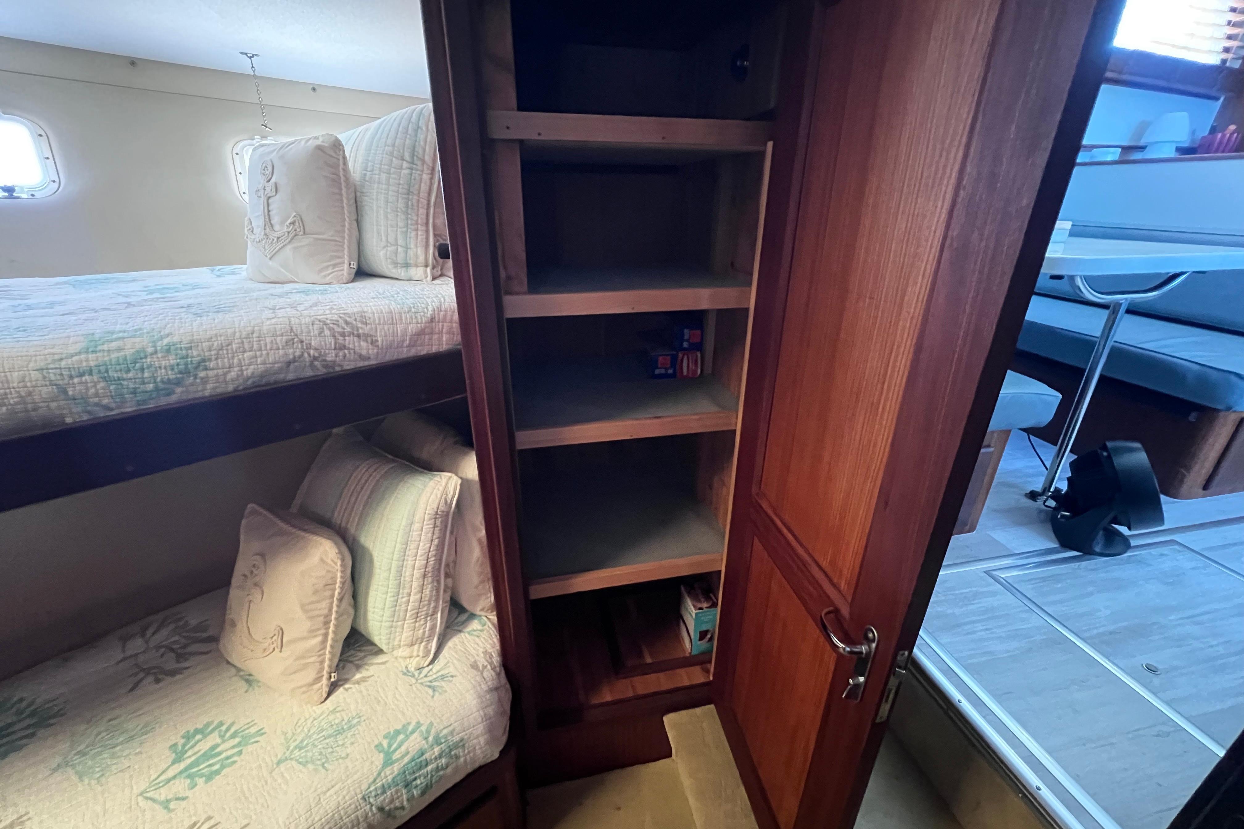 Interior of 1987 Hatteras 70 Cockpit Motor Yacht with bunk beds and wooden storage cabinet.