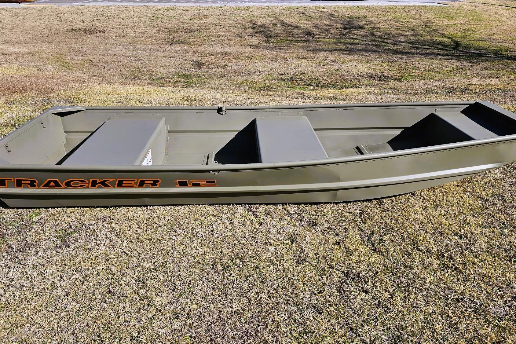 2026 Tracker Grizzly 12 Jon boat on grassy terrain, showcasing its sturdy design.