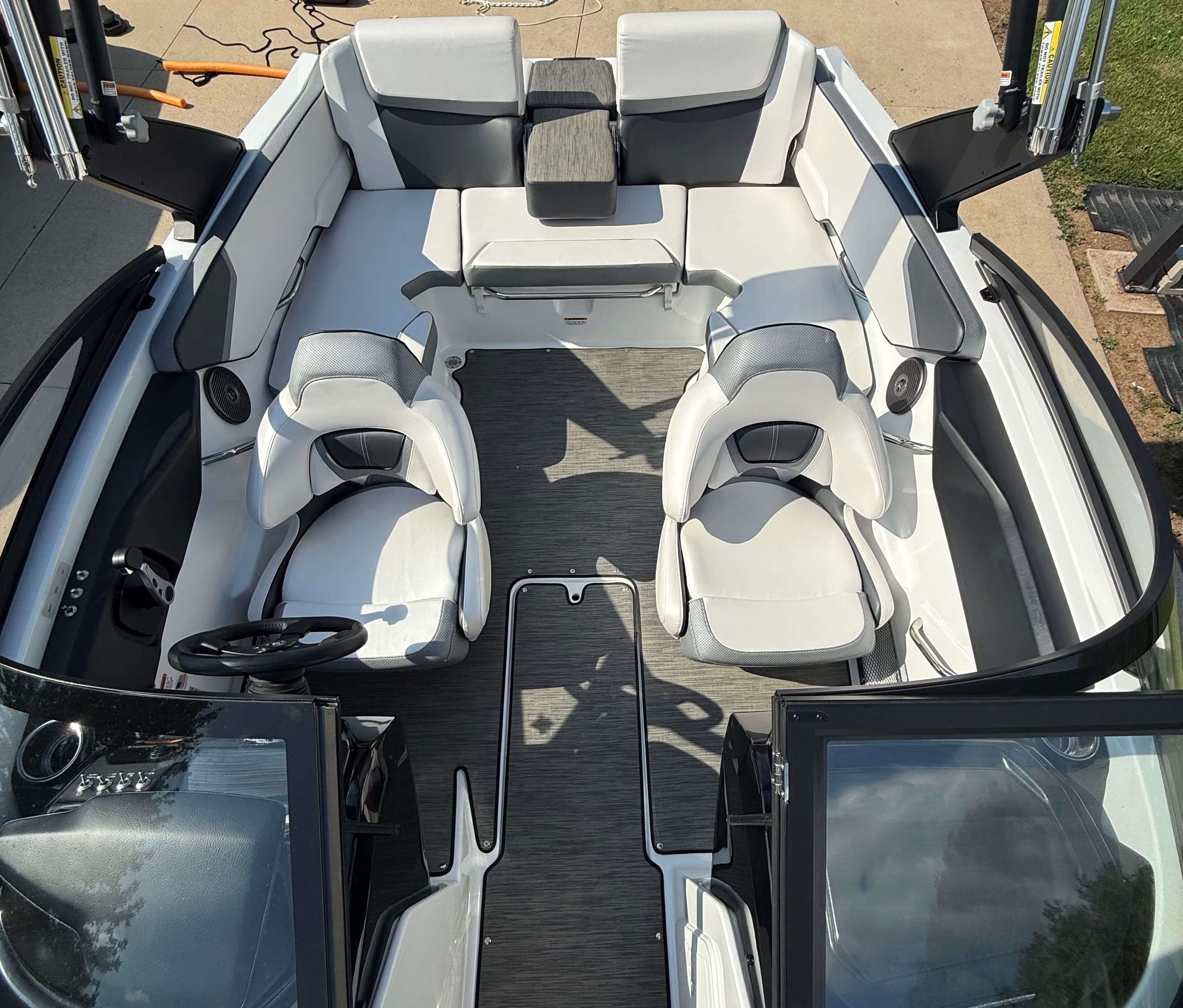 The image shows the cockpit of a 2023 Scarab 195 ID boat with white and gray seating.