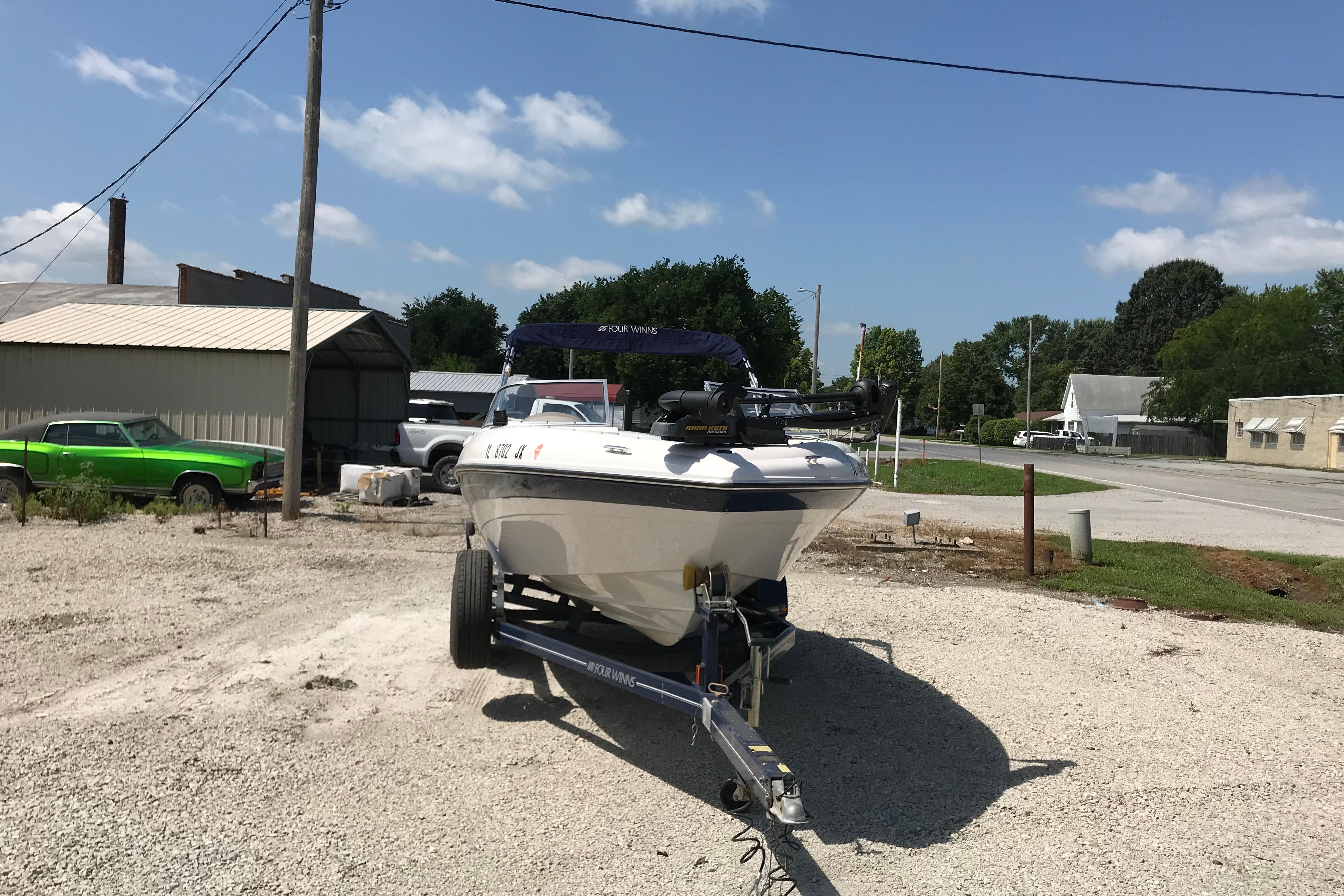 2005 Four Winns 180 Horizon FS boat on trailer in a rural setting.